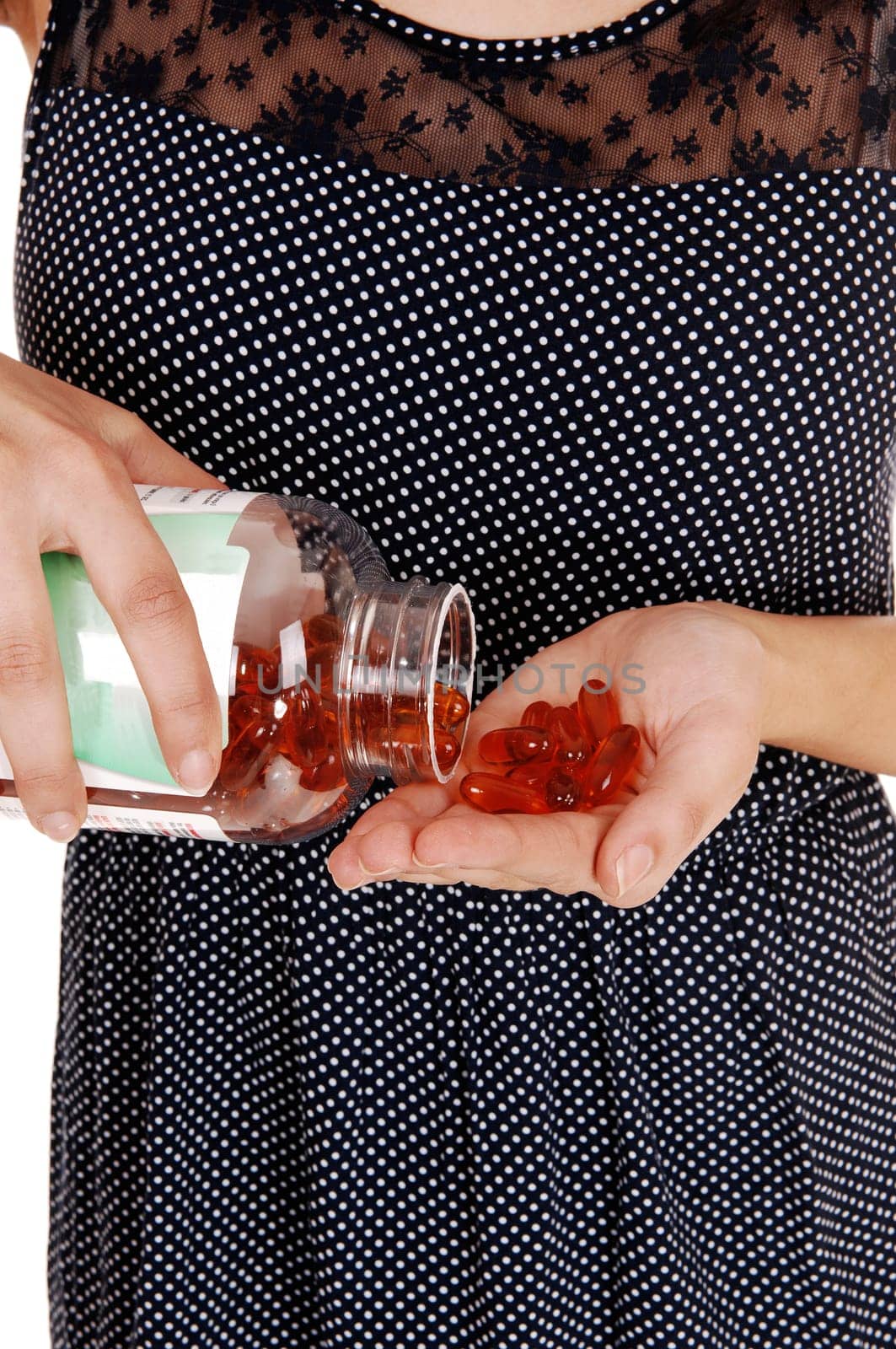 A closeup picture of the body of a young woman holding a bottle with.vitamin capsule, isolated on white background..