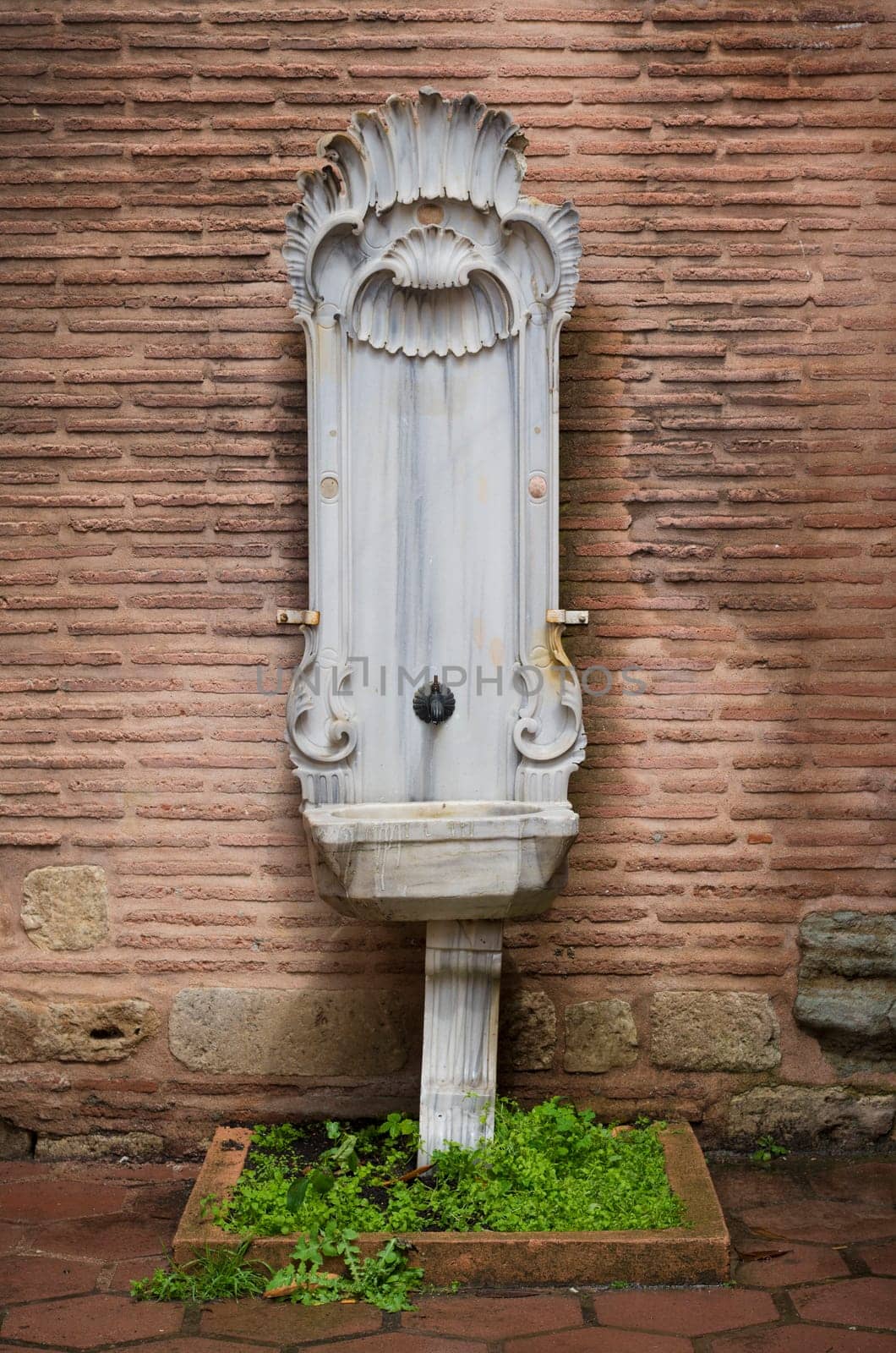 beautiful marble fountain against a brick wall