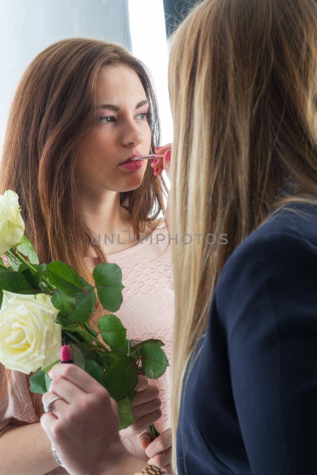 Make-up woman makes up a girl