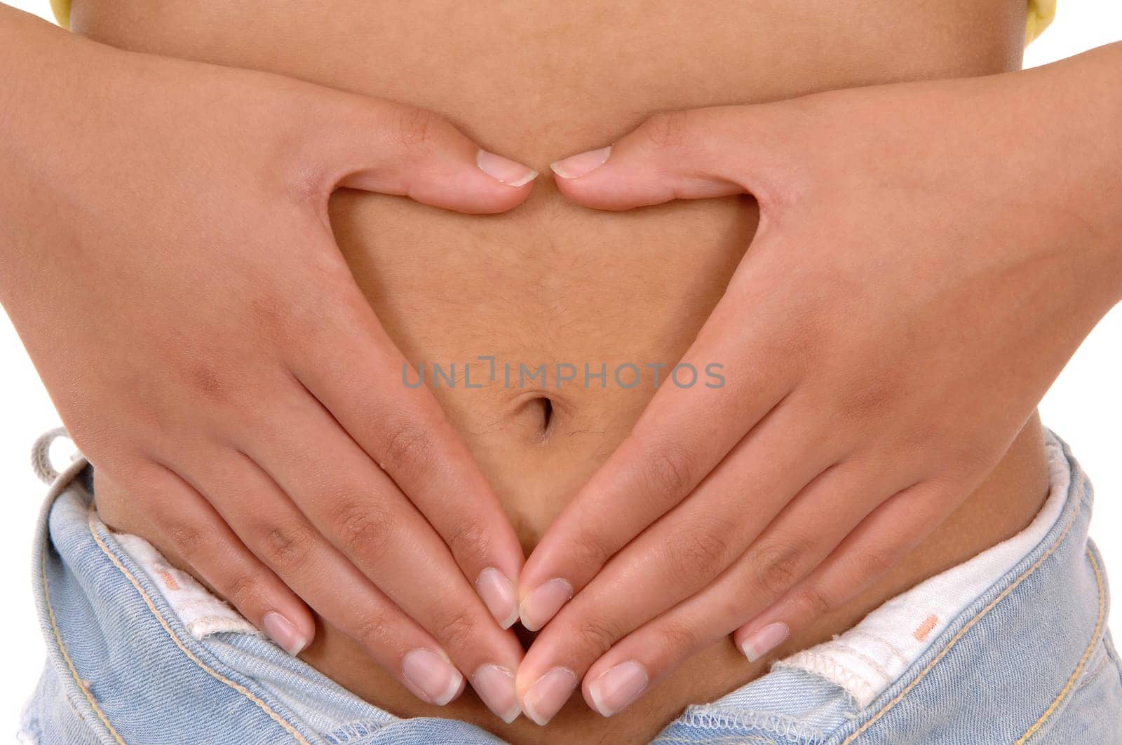 A young woman holding her hands on her stomach and making a heart,.body part isolated on white background..