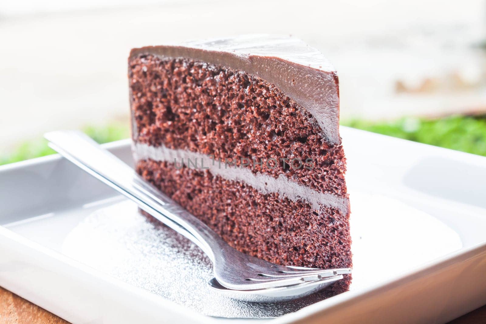 Close up chocolate custard cake serving with spoon and fork