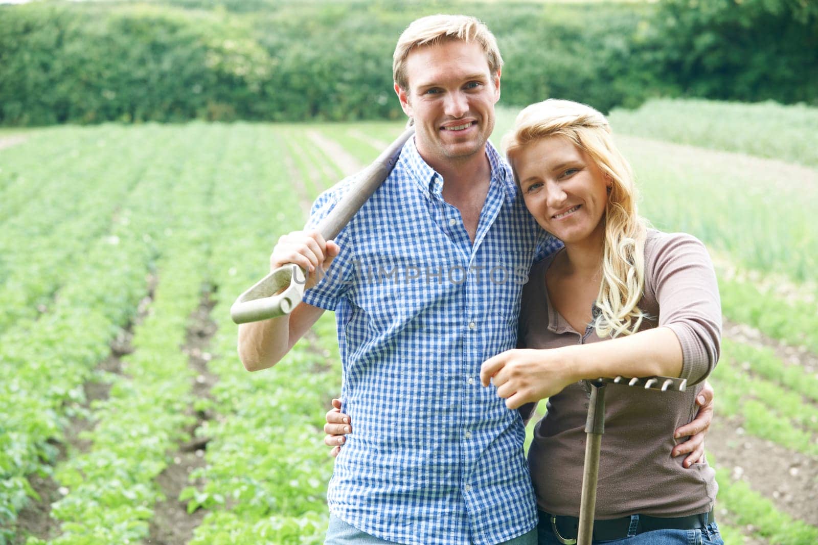 Couple Working In Field On Organic Farm
