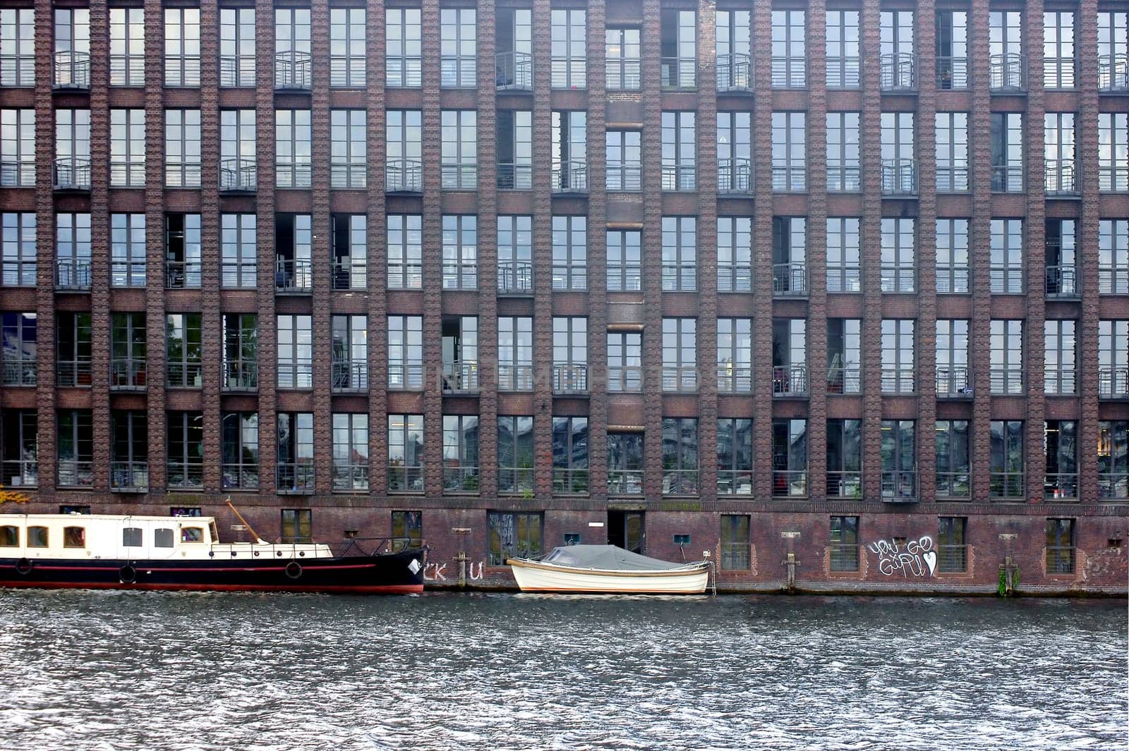 The photograph of an old brick building with offices on the Spree in Berlin.