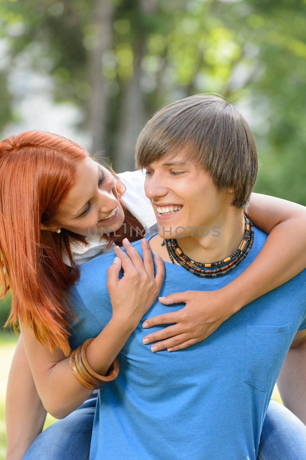 Loving couple piggyback hugging in sunny park enjoy first love