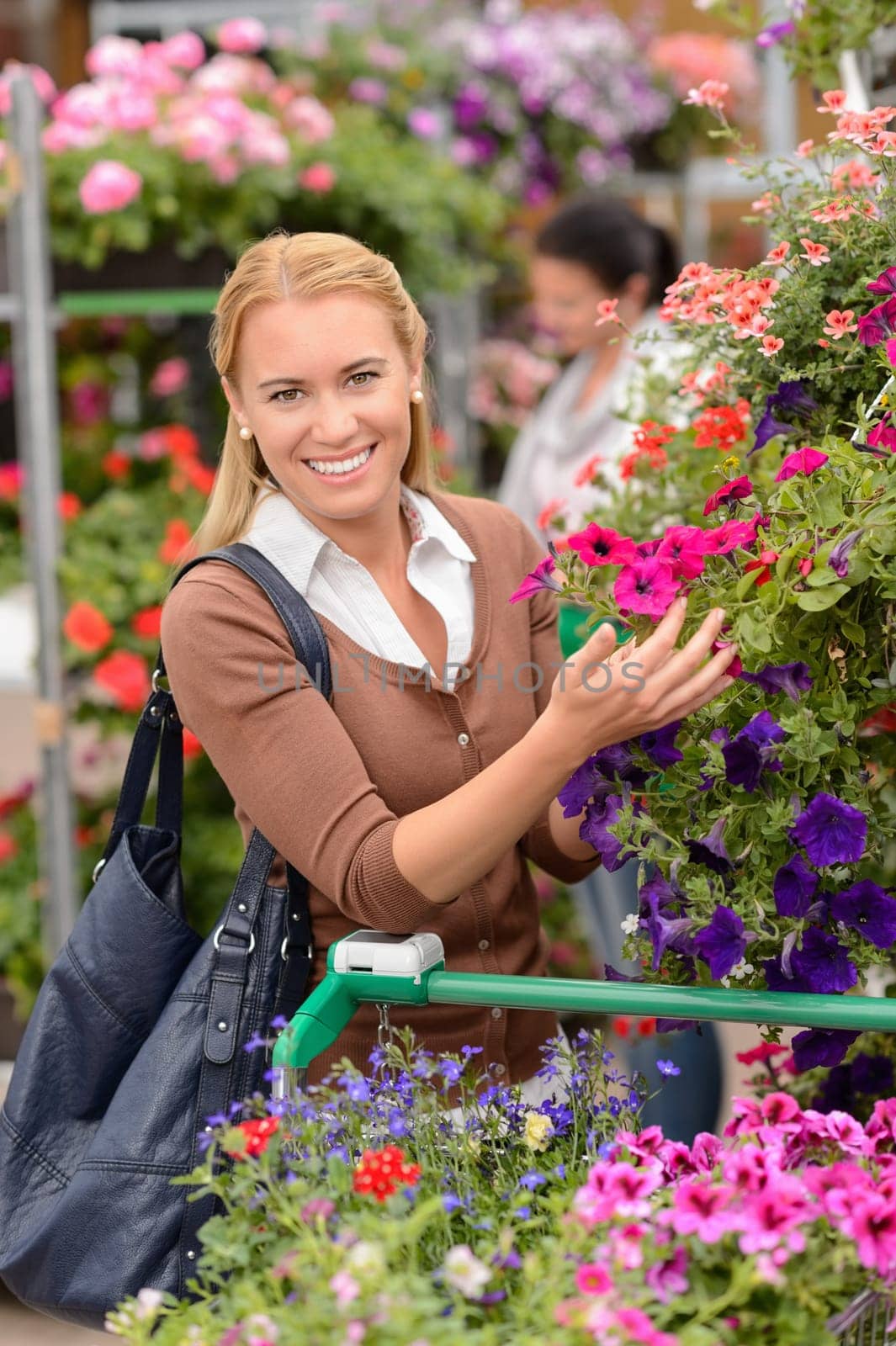 Smiling woman shopping for colorful flowers in garden center