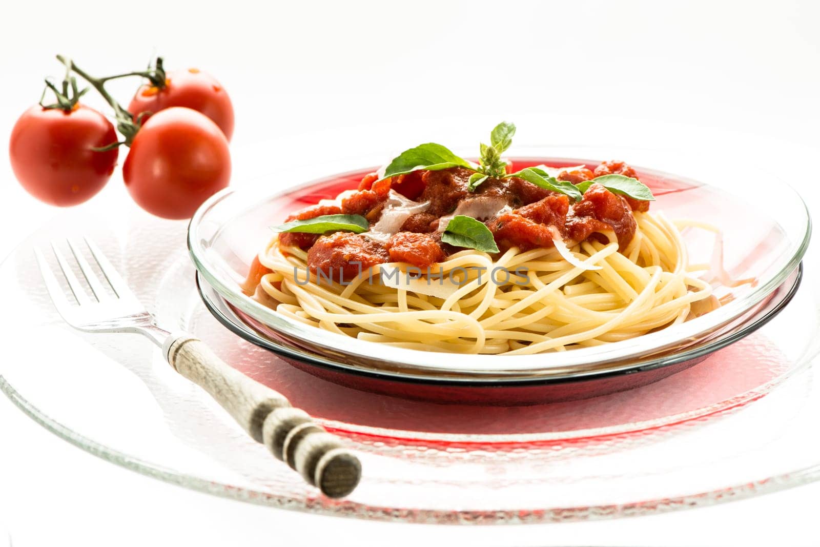Spaghetti with tomato sauce on a plate of glass