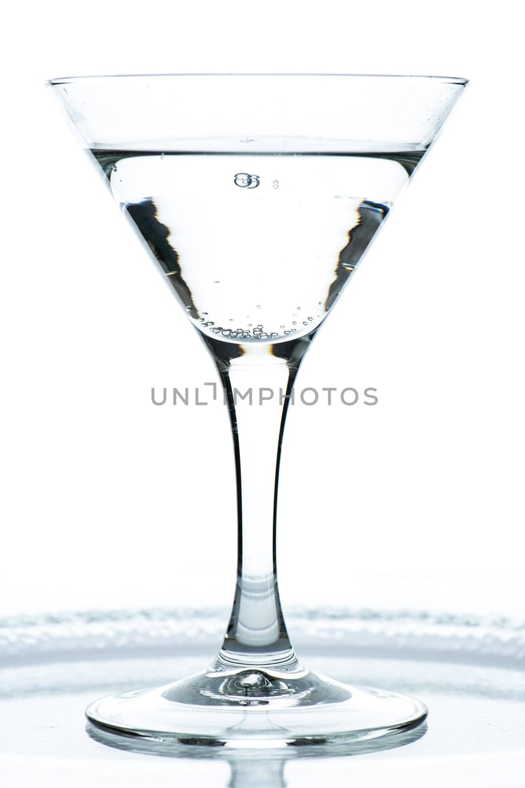 Glass with gin tonic and carbonic acid in the backlight