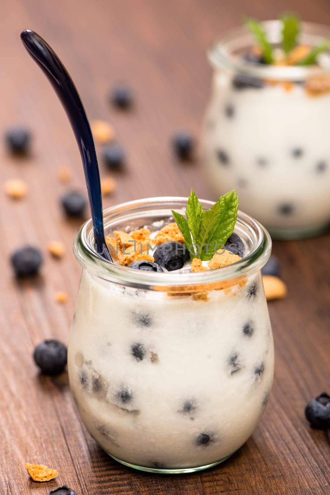 Glass of yoghurt with blueberries,mint and cantuccini