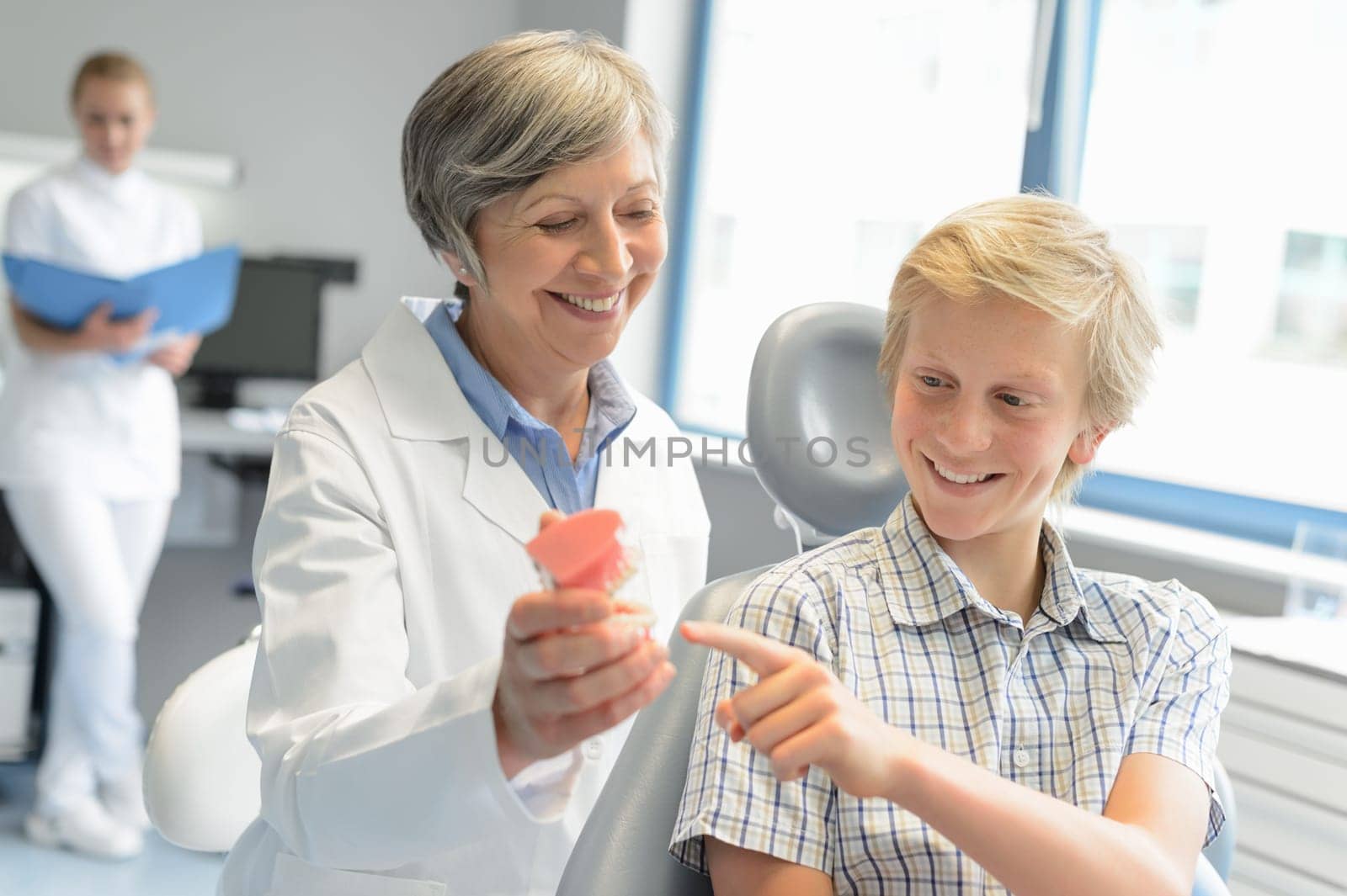 Teenage boy point teeth denture dentist checkup at dental surgery