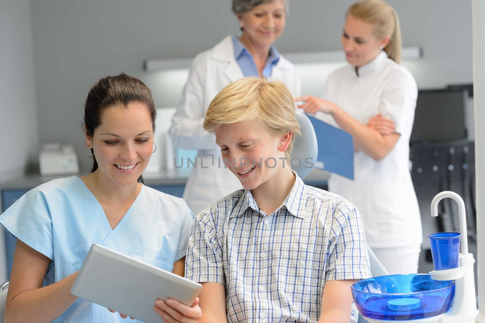 Teenager patient with professional dentist team point tablet dental surgery