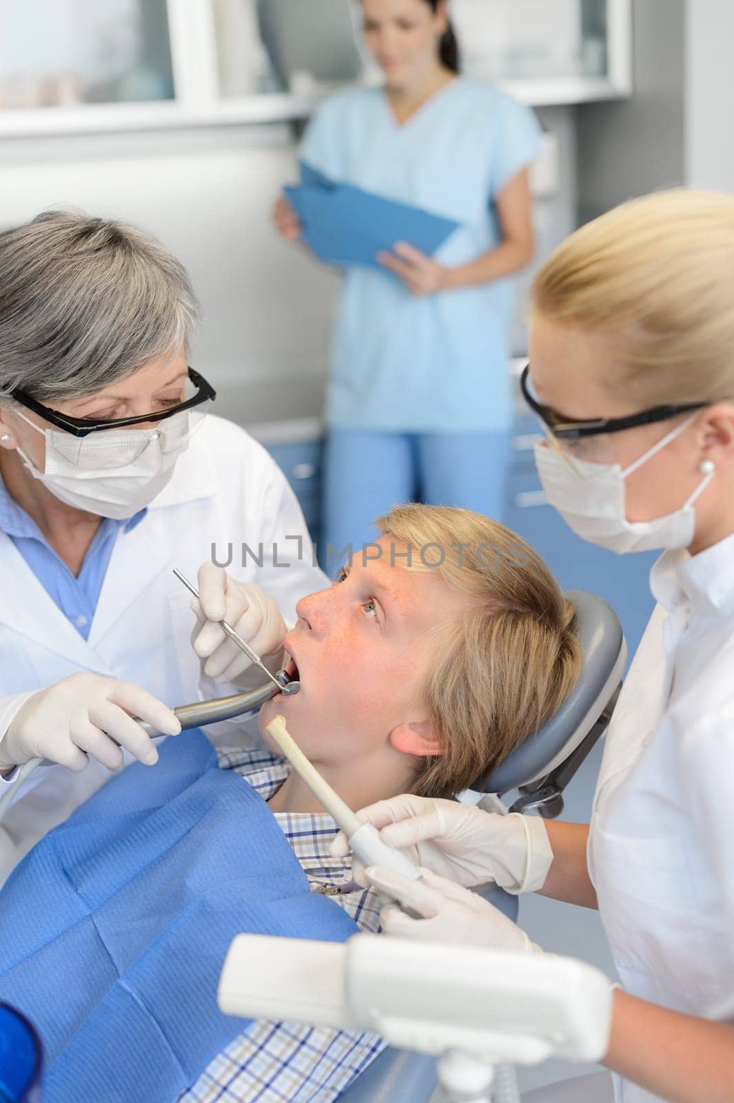 Dentist with nurse treatment on teenager patient at dental surgery