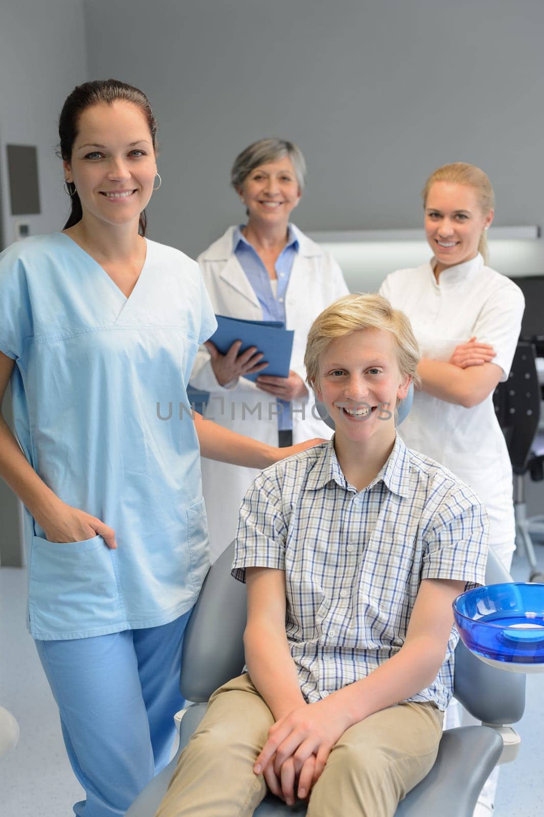 Team of dentists with teenager patient boy at dental surgery