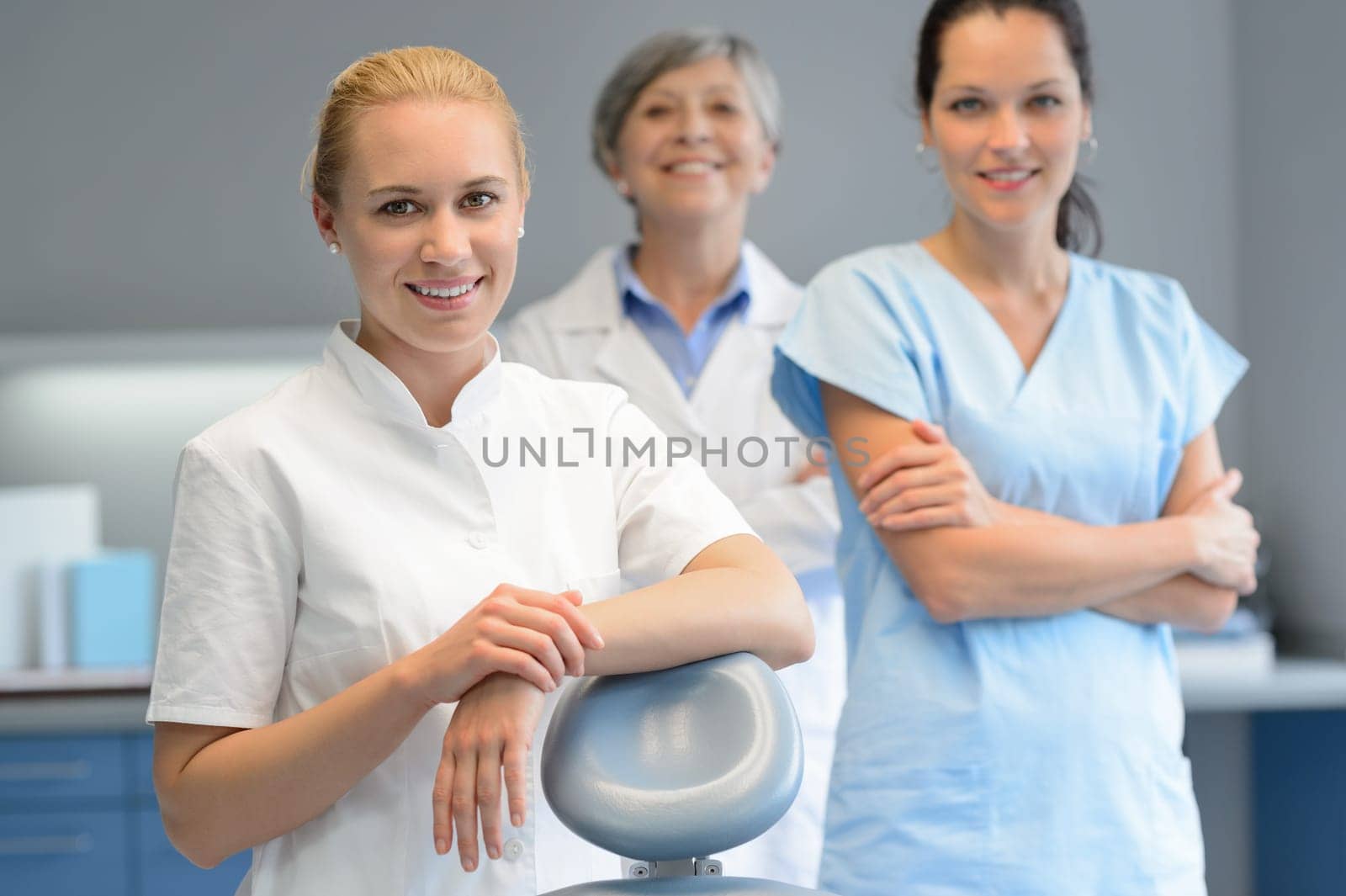 Three professional dentist woman team standing dental surgery  looking camera