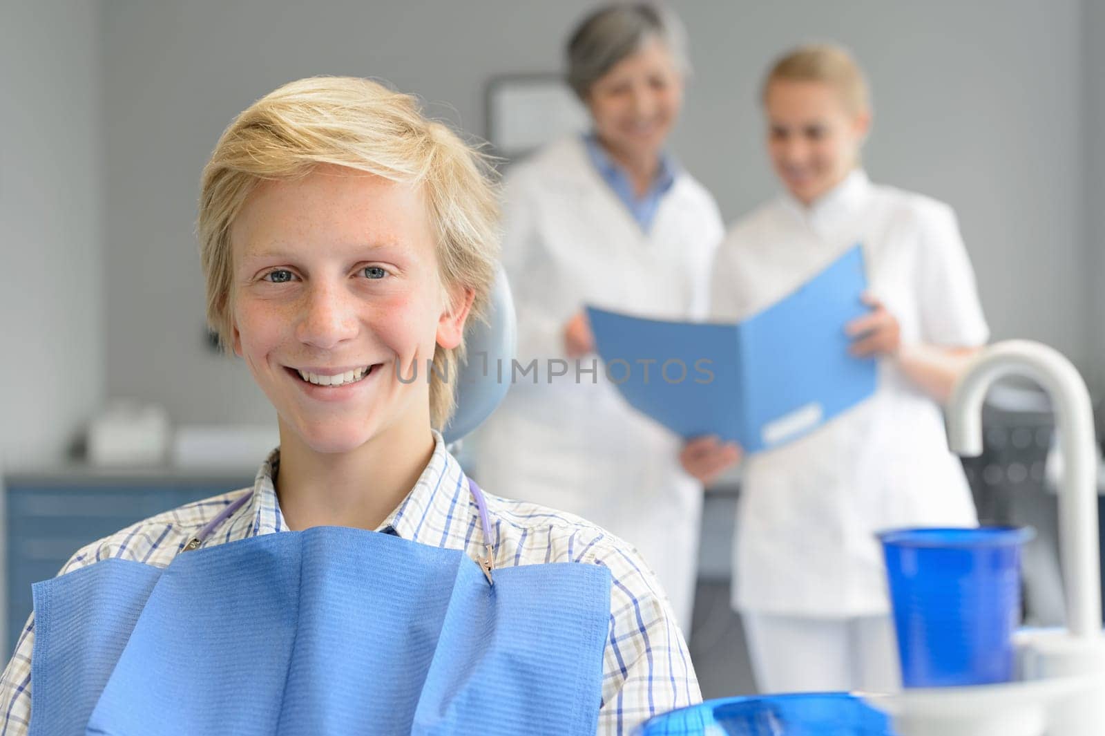 Teenage patient at dental surgery teeth check dentist woman nurse