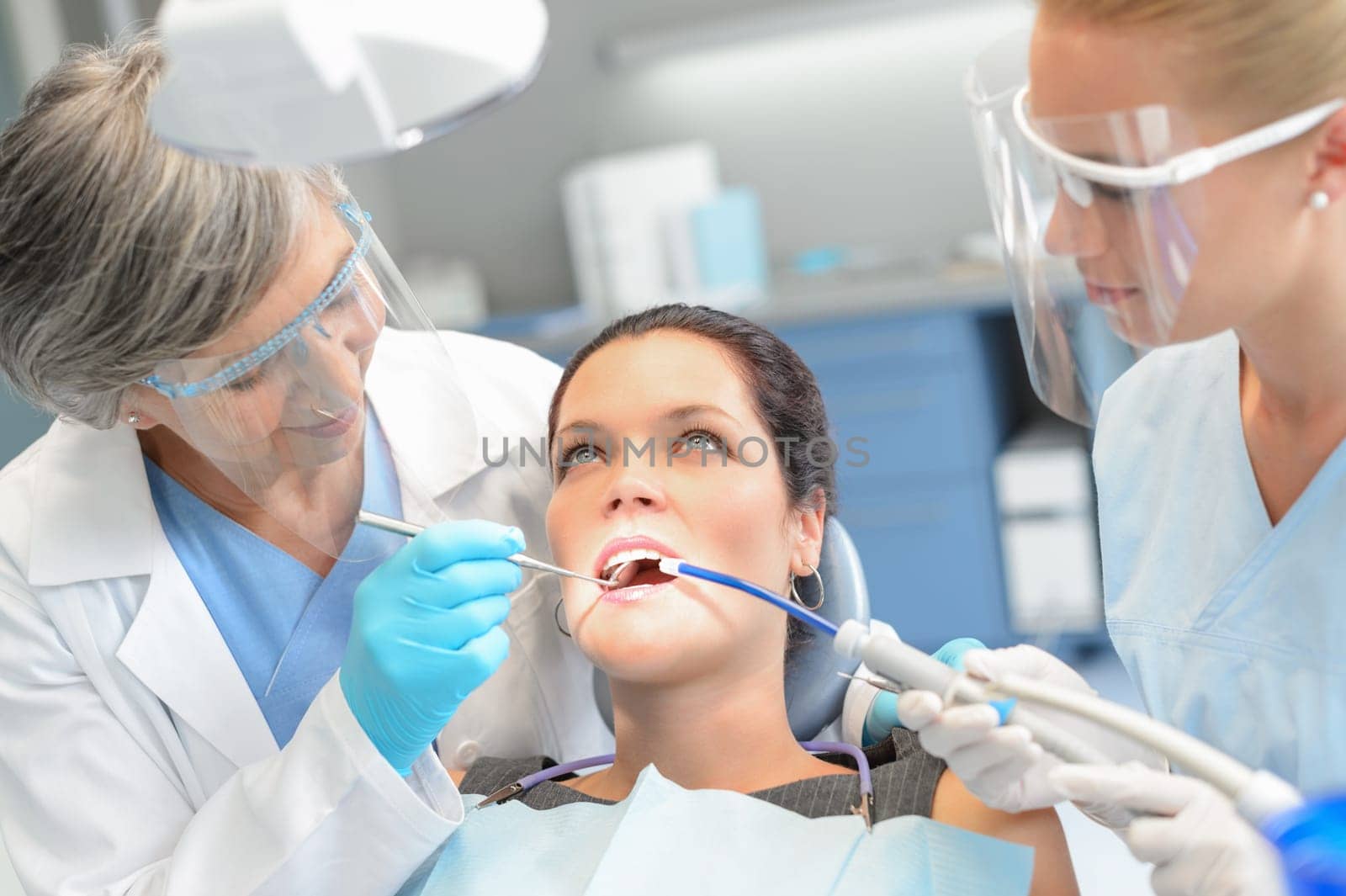 Woman patient dental check open mouth professional dentist team