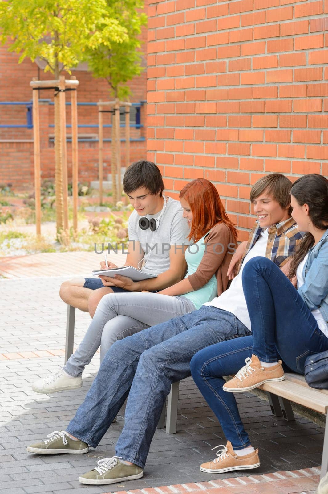 Group of students friends hanging out sitting outside college campus
