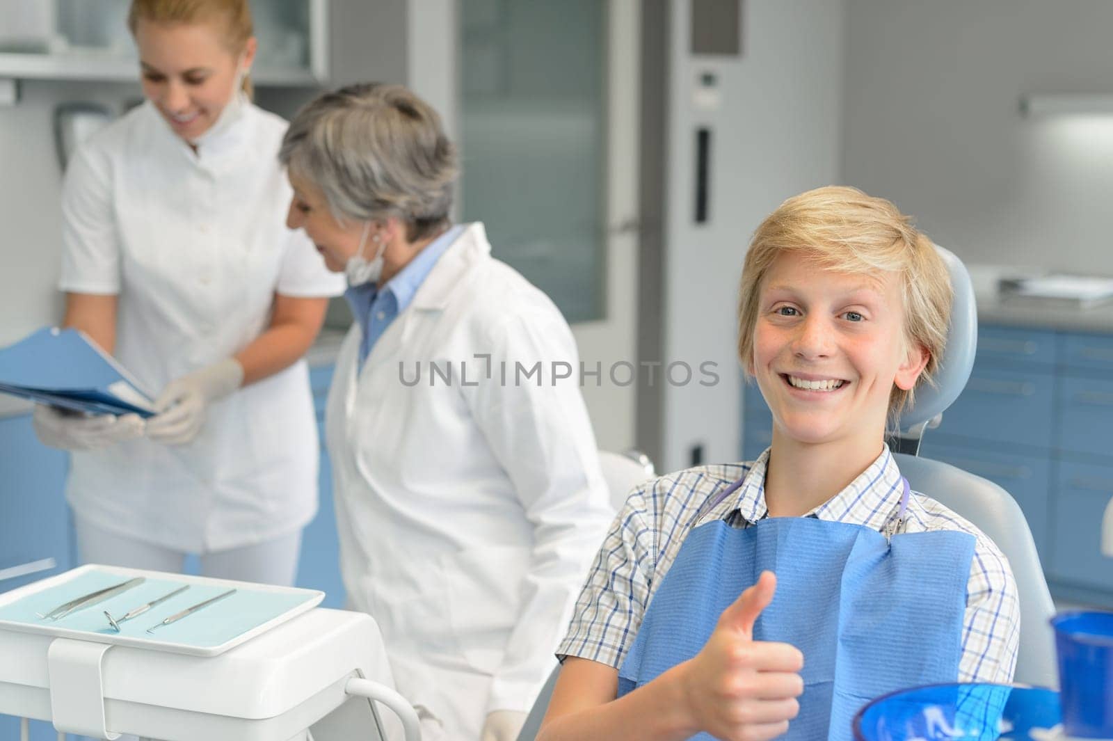 Teenage boy patient teeth checkup at dental surgery dentist woman
