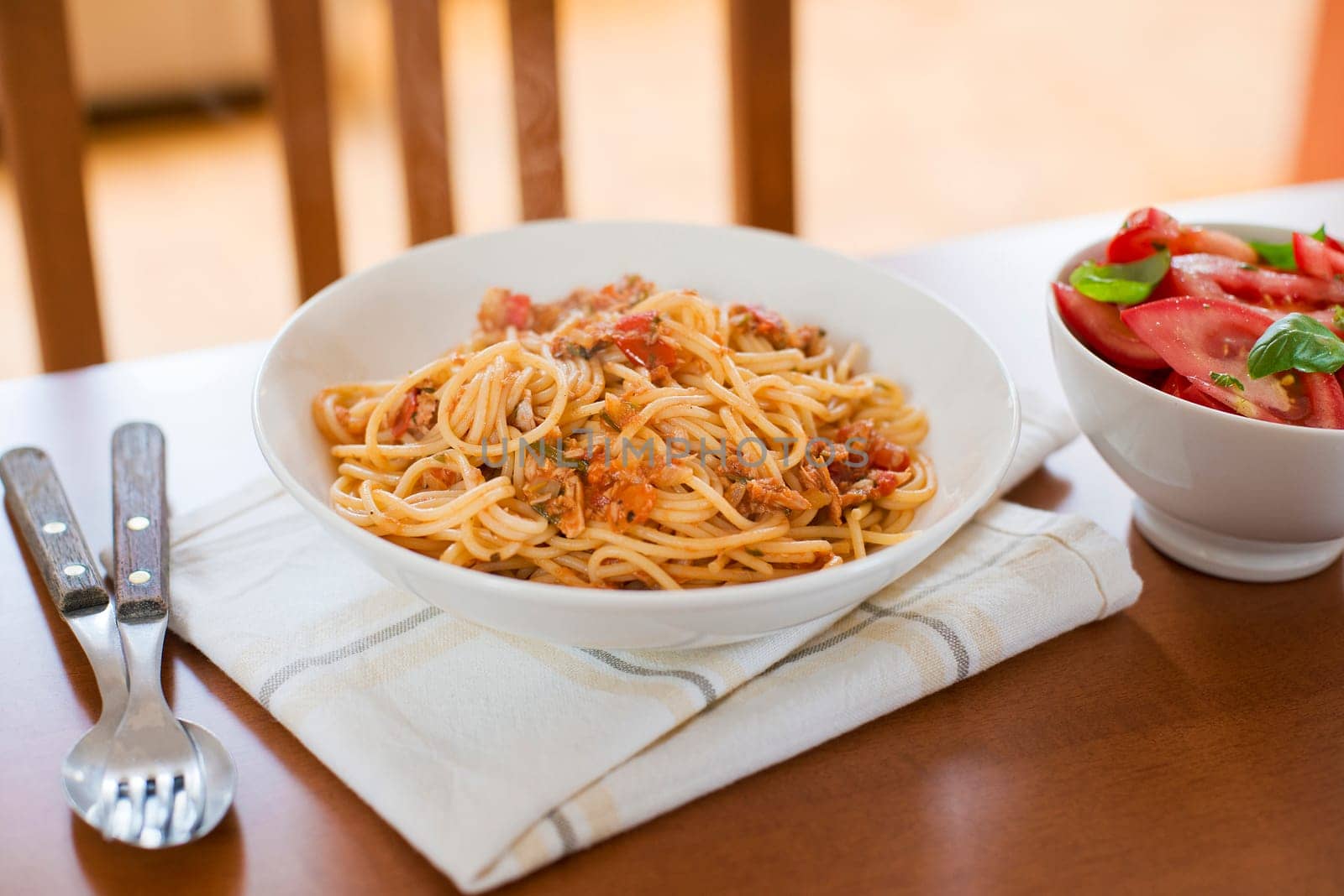 Spaghetti with tomato and tuna sauce on wooden table