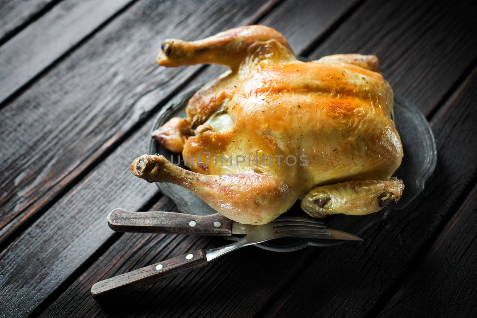 Whole roasted chicken on a wooden table