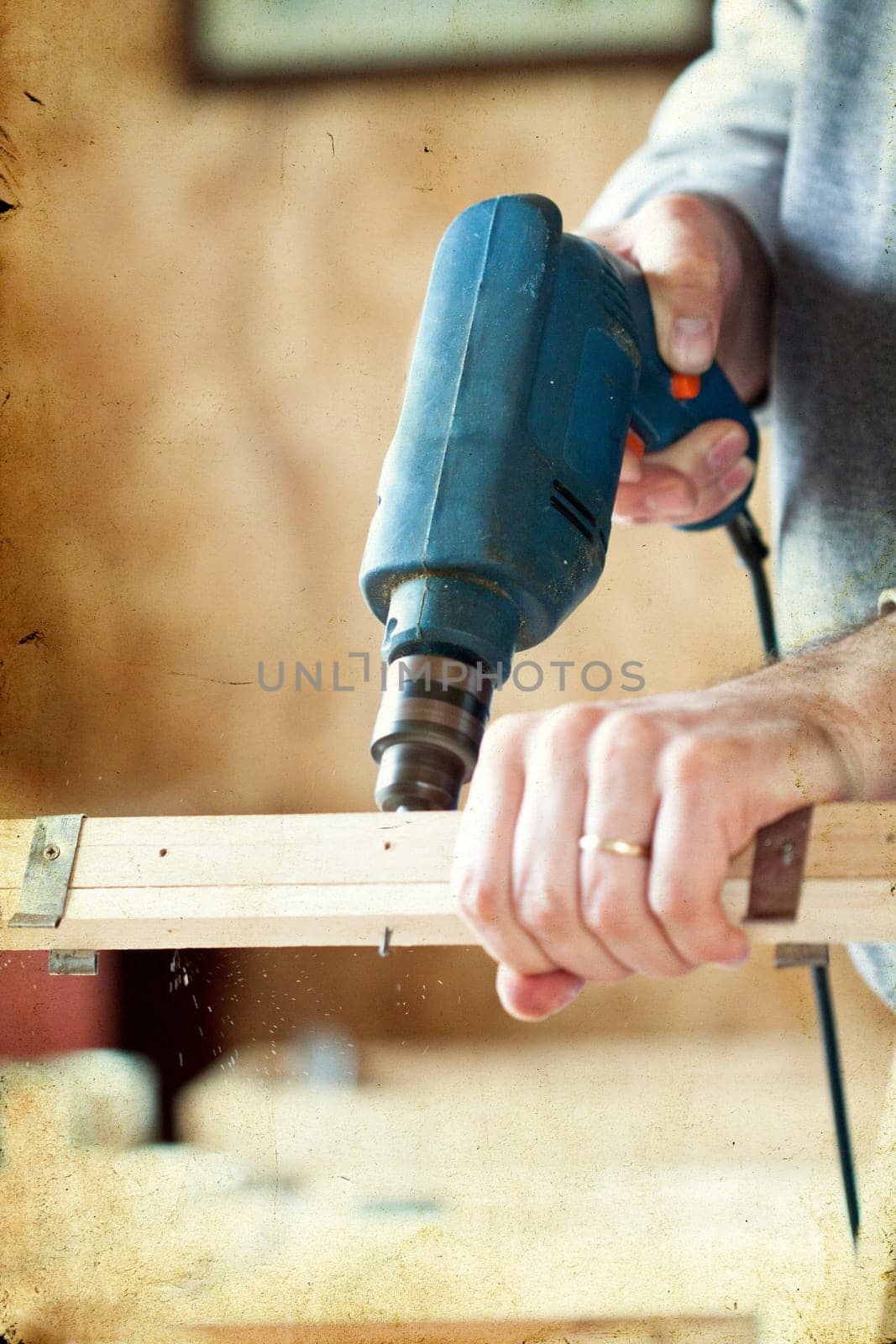 Man's arms drill lath in the workshop - vintage photo