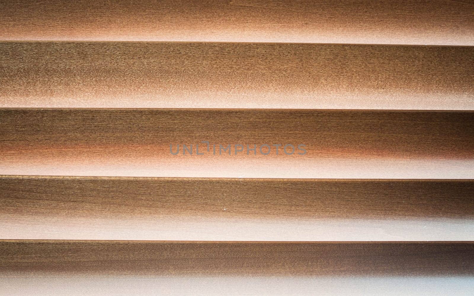 Dim light  through wooden jalousie at a window