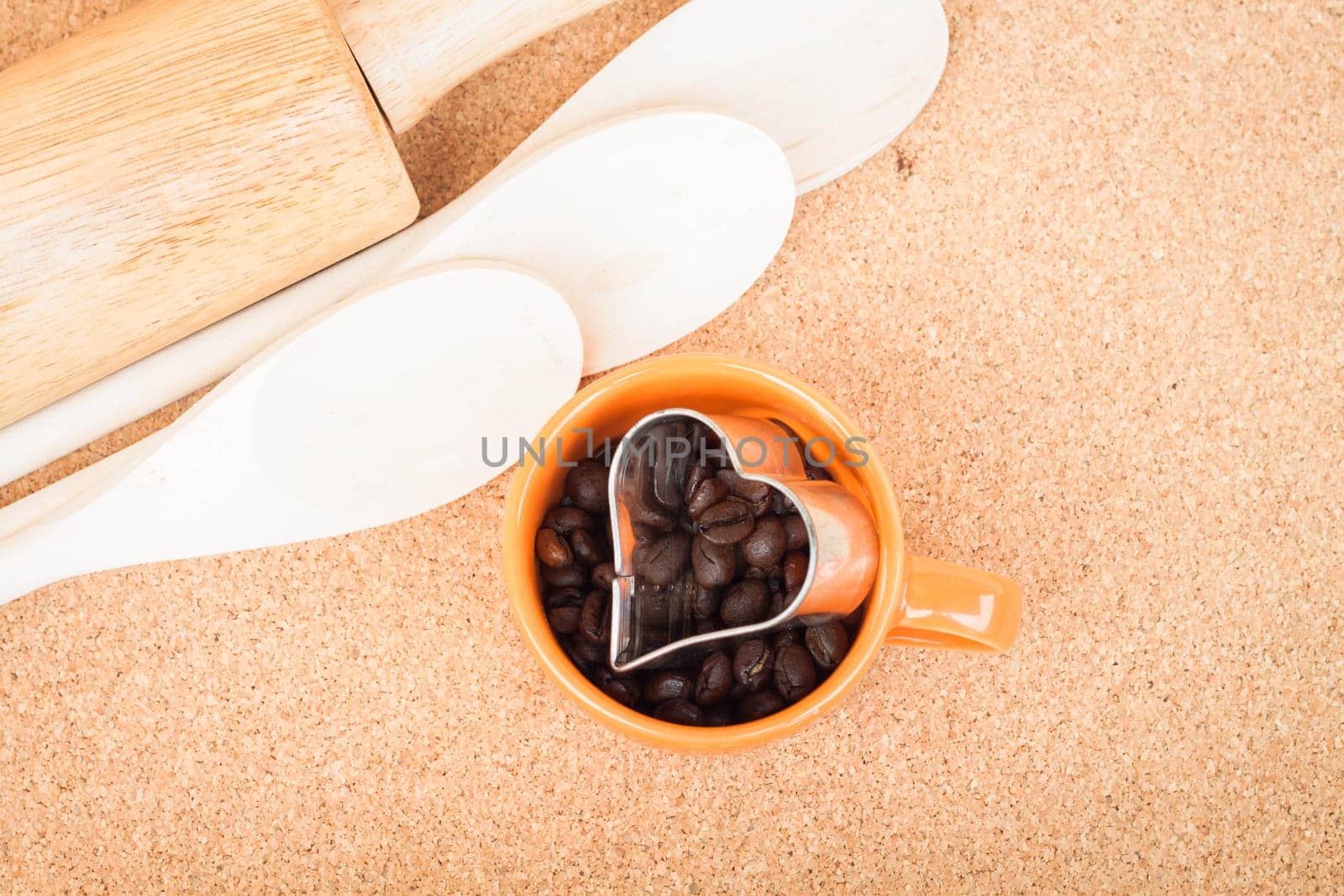 Cup of coffee bean and cookies cutter in kitchen