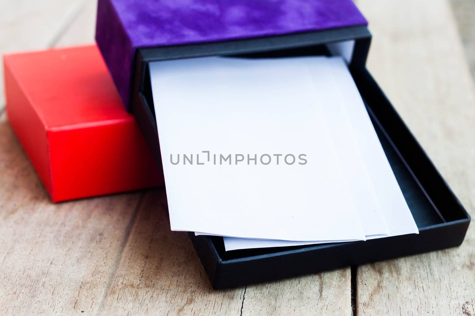 Envelopes in open gift box on wooden table