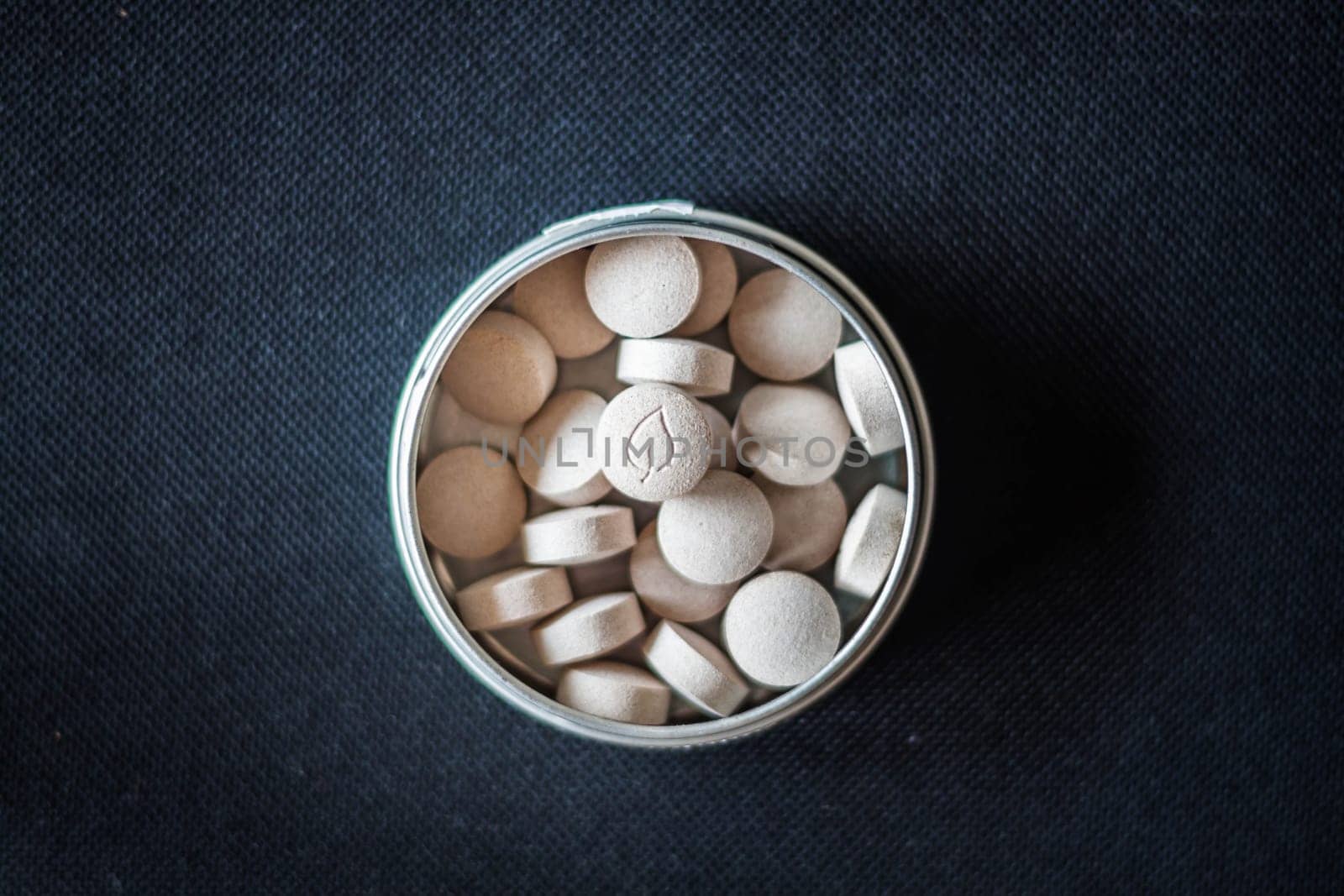 Natural vitamin pills in package on dark background