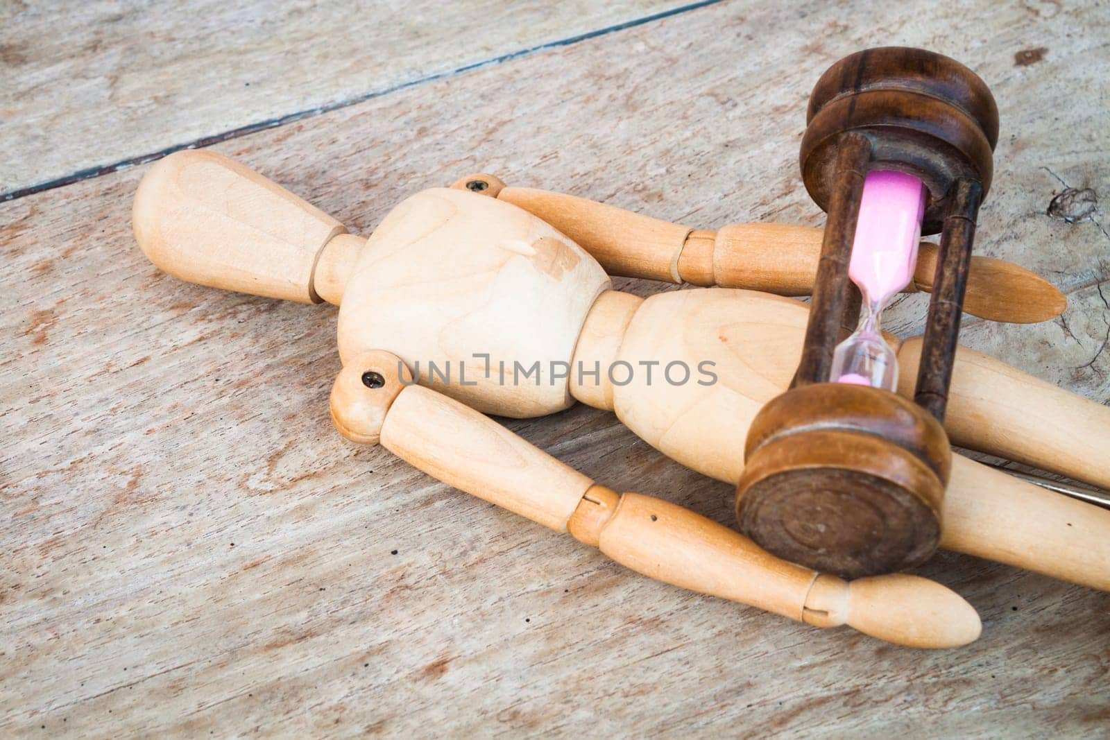 Wood mannequin and hourglass display time relaxing