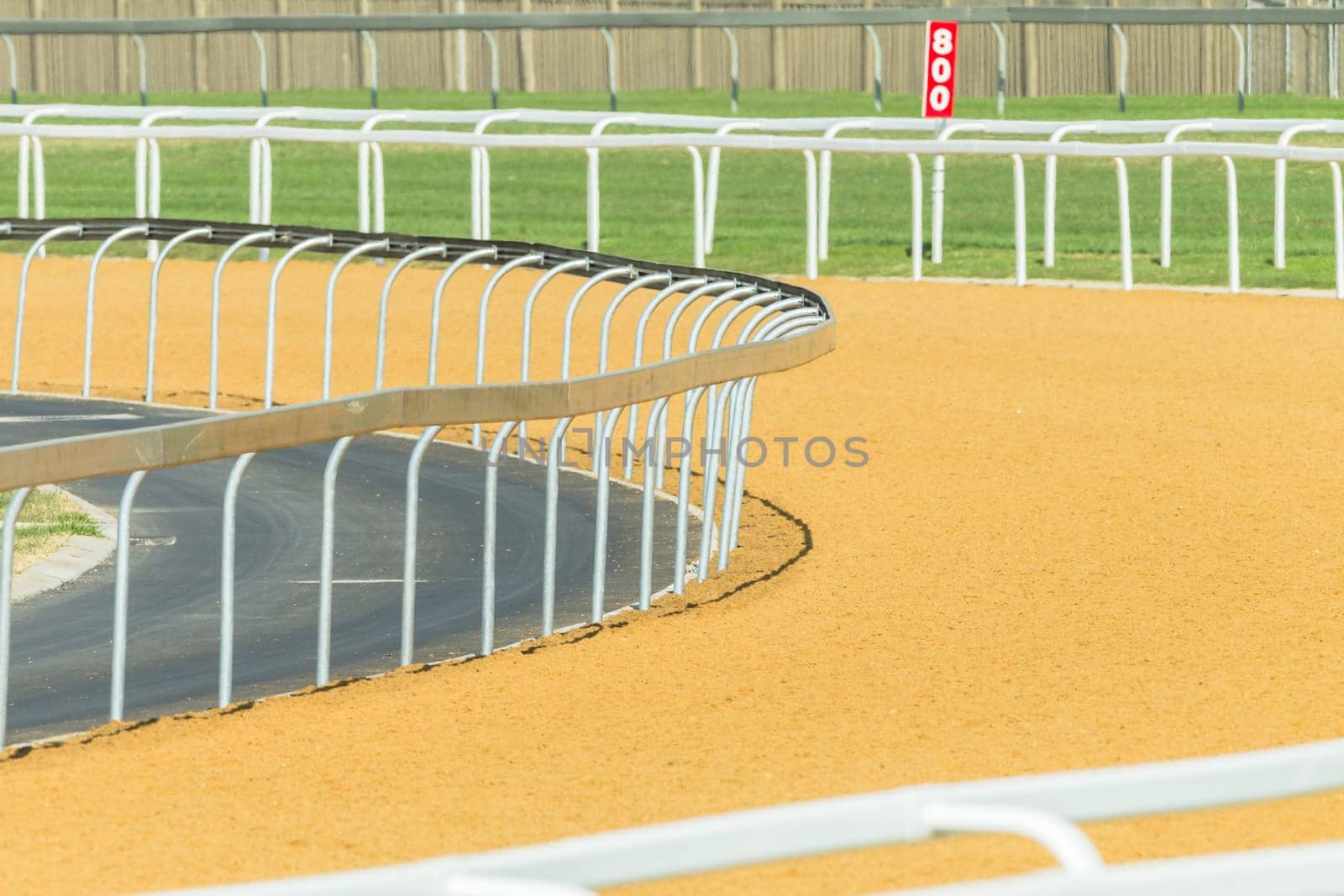Horse racing tracks section poly synthetic and grass with railing.