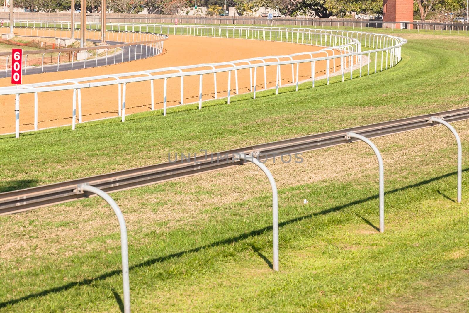 Horse racing tracks section poly synthetic and grass with railing.