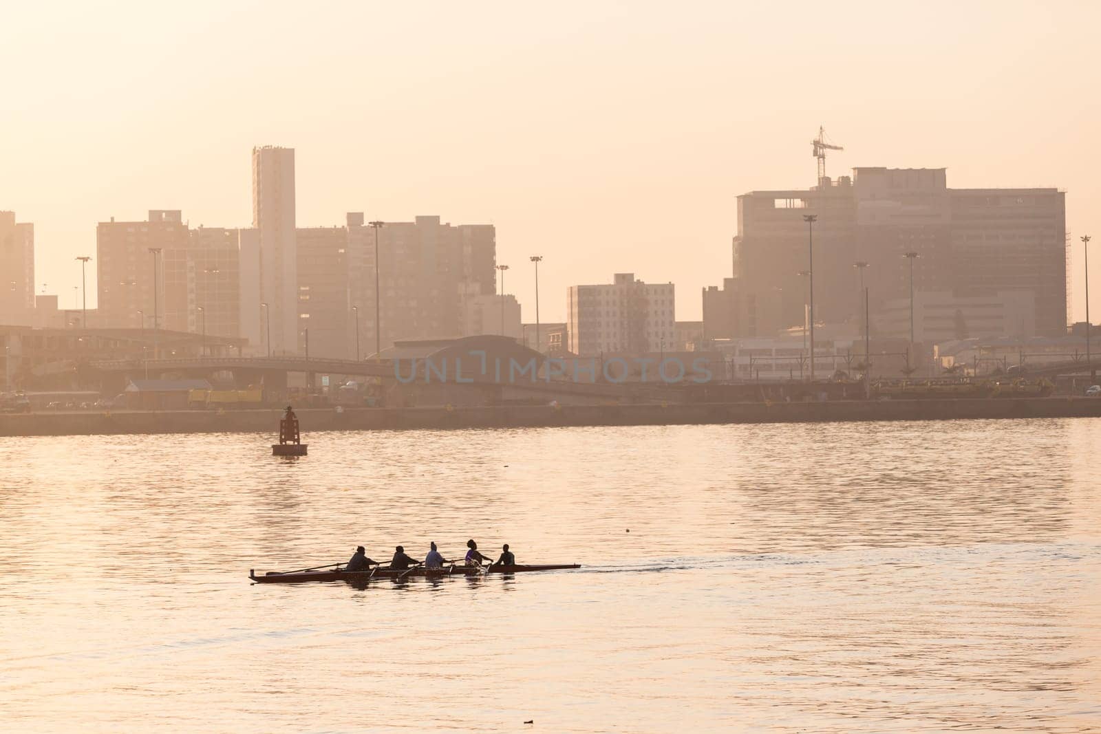 Regatta rowing crews eights quads doubles skulls on race course silhouetted on morning sunrise colors on sea waters at Durban Rowiing Club Head of the Bay Regatta July 12th 2014 Durban South-Africa