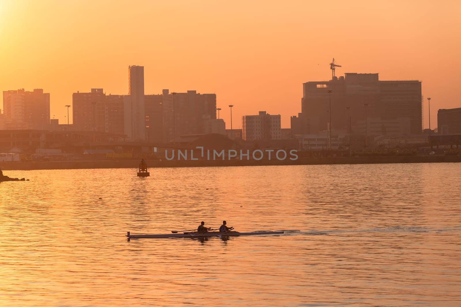 Regatta rowing crews eights quads doubles skulls on race course silhouetted on morning sunrise colors on sea waters at Durban Rowiing Club Head of the Bay Regatta July 12th 2014 Durban South-Africa