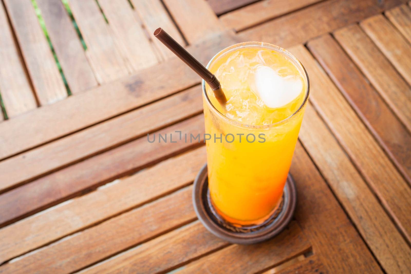 Romantic orange juice with heart ice cube