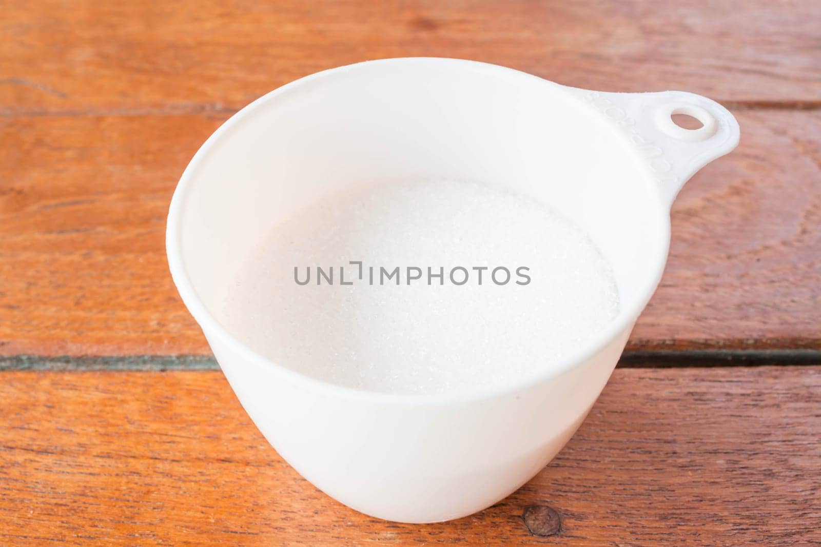 Bakery white sugar measured in plastic cup