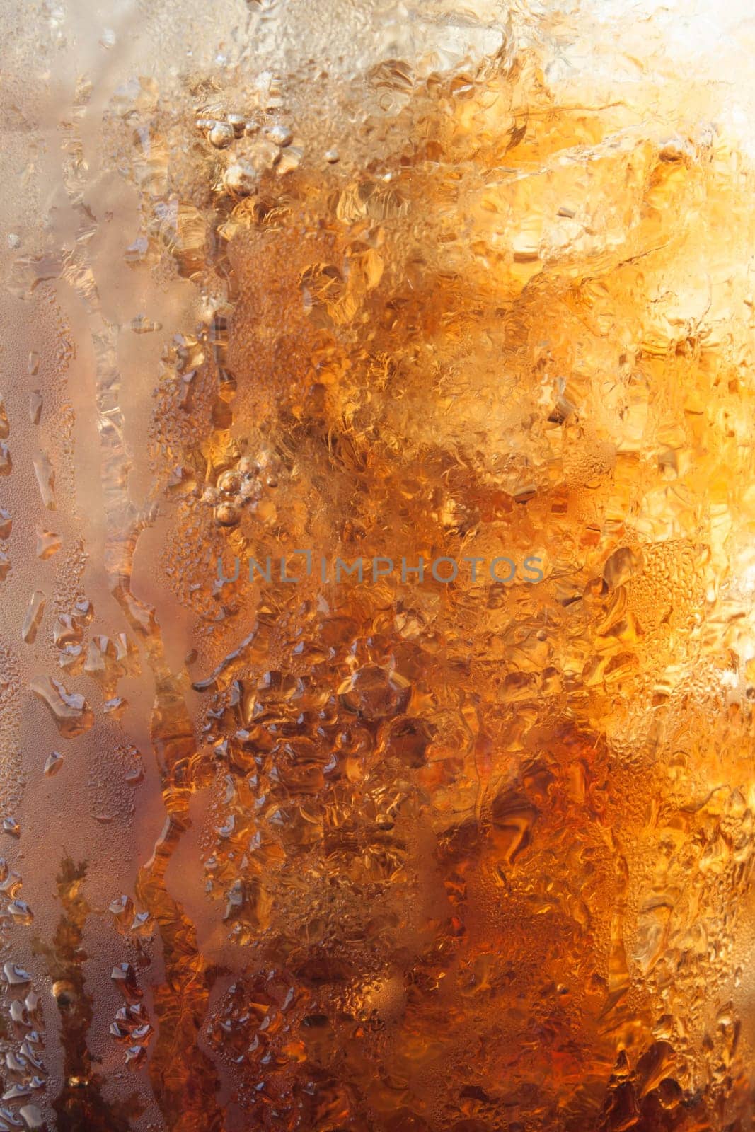 Gradient of fizzy ice cola in a glass