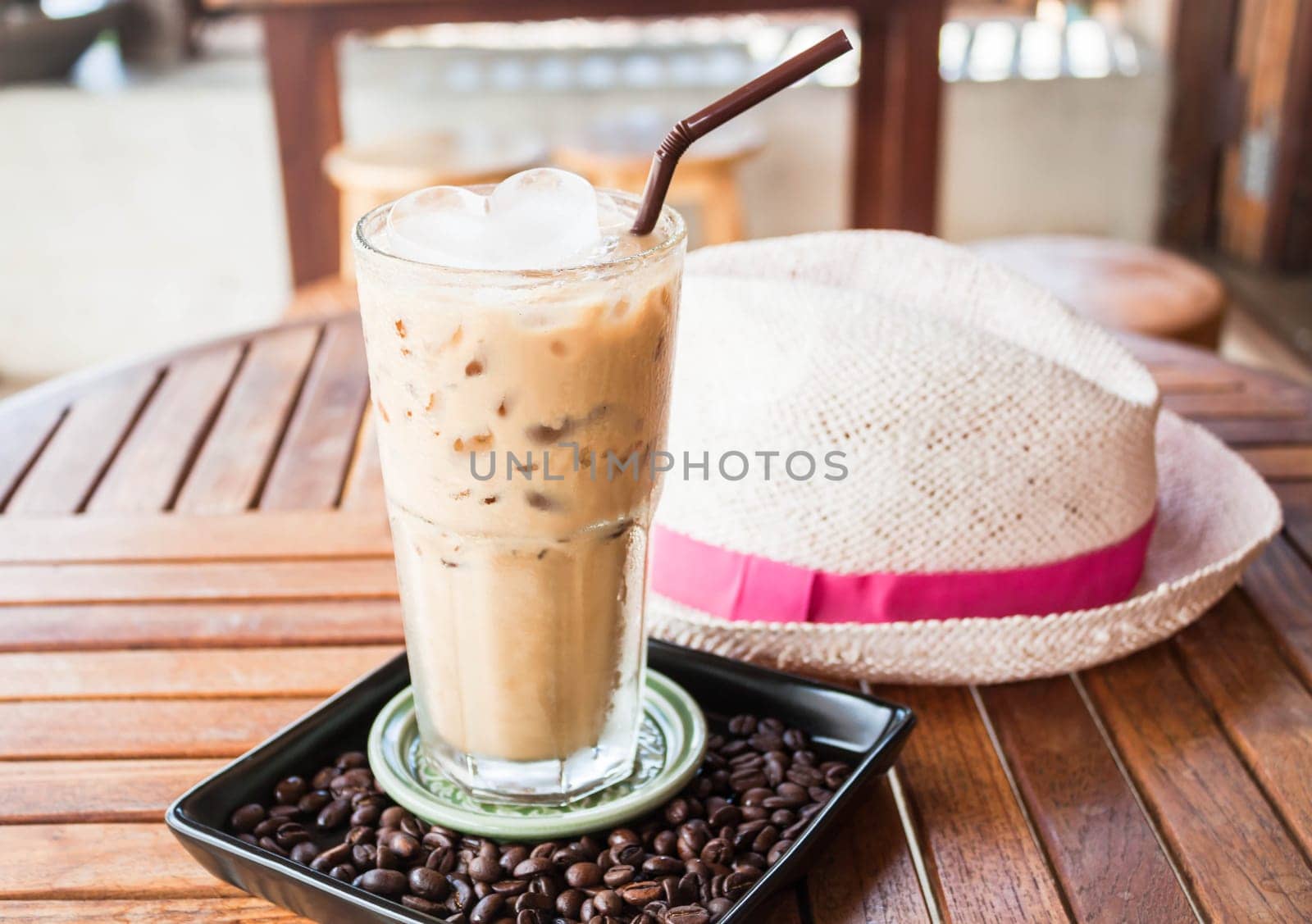 Cold glass of iced milk coffee with ice cube