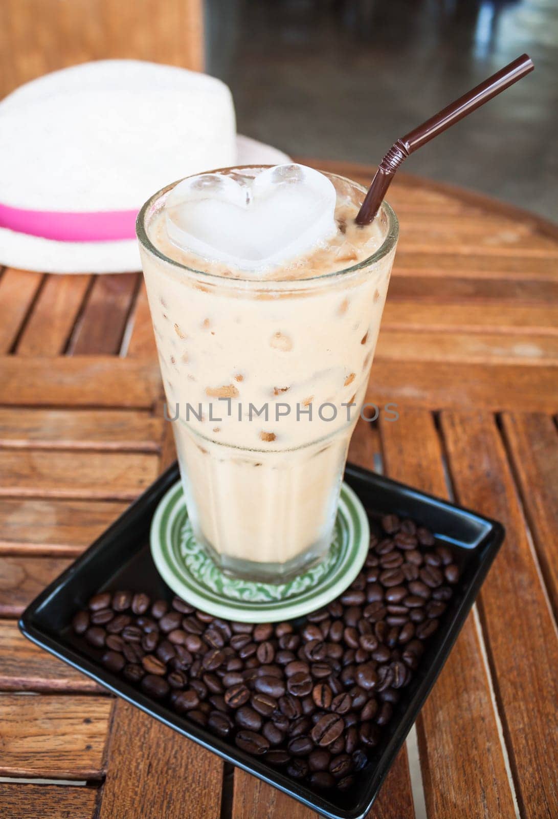 Cold glass of milk espresso and heart ice cube