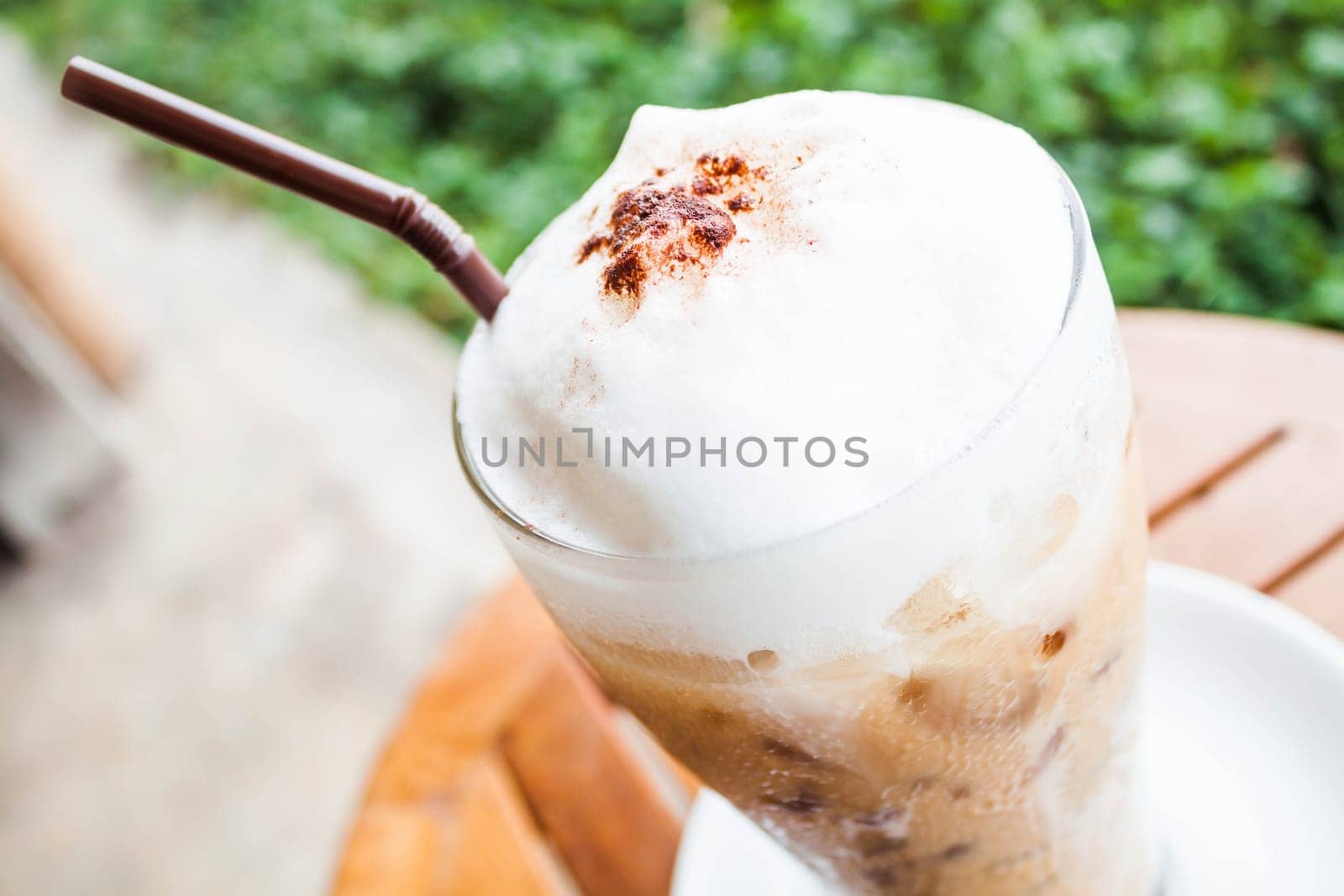 Refreshing glass of iced blended frappucino with milk foam