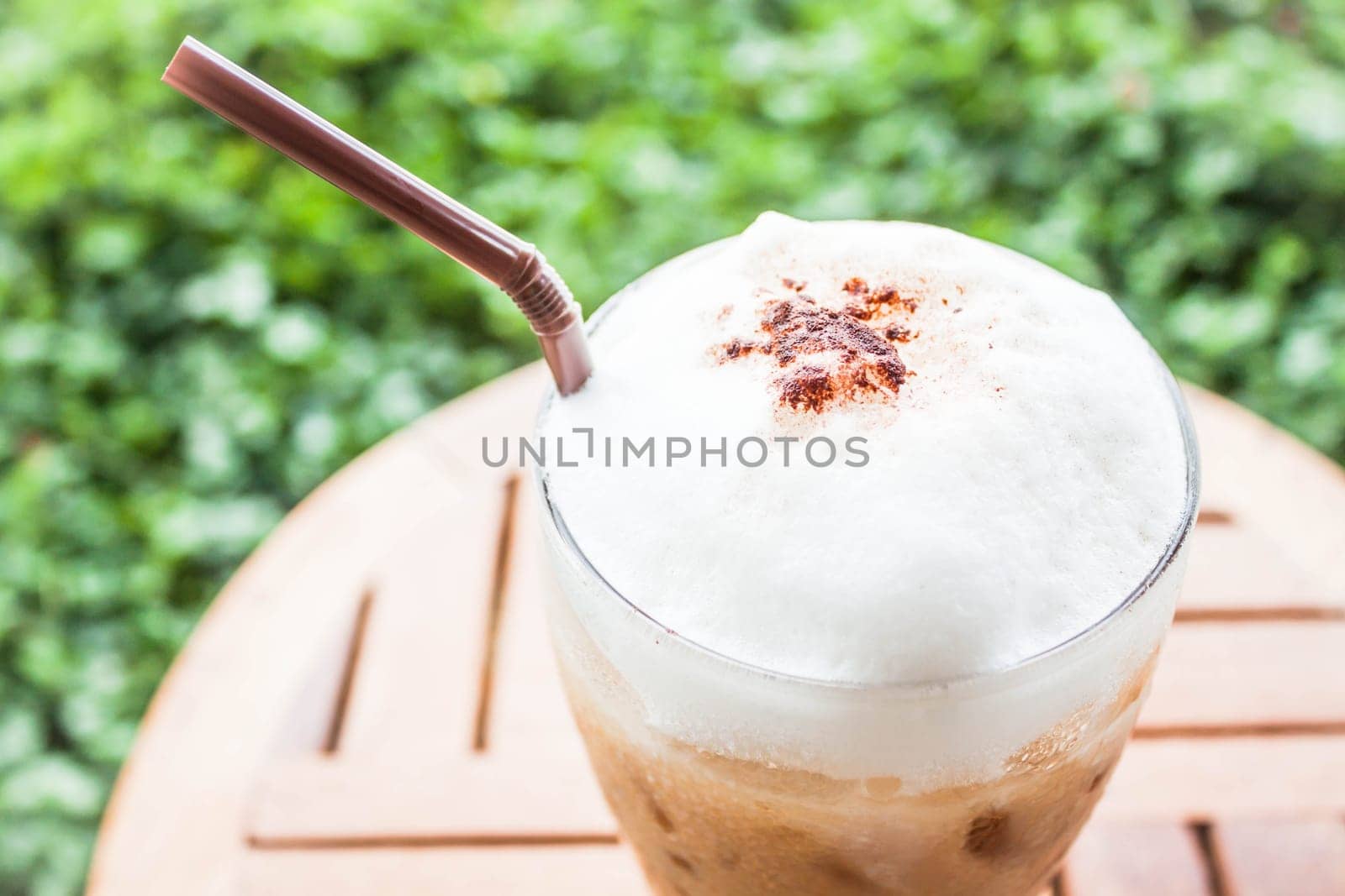 Refreshing glass of iced blended espresso with milk foam