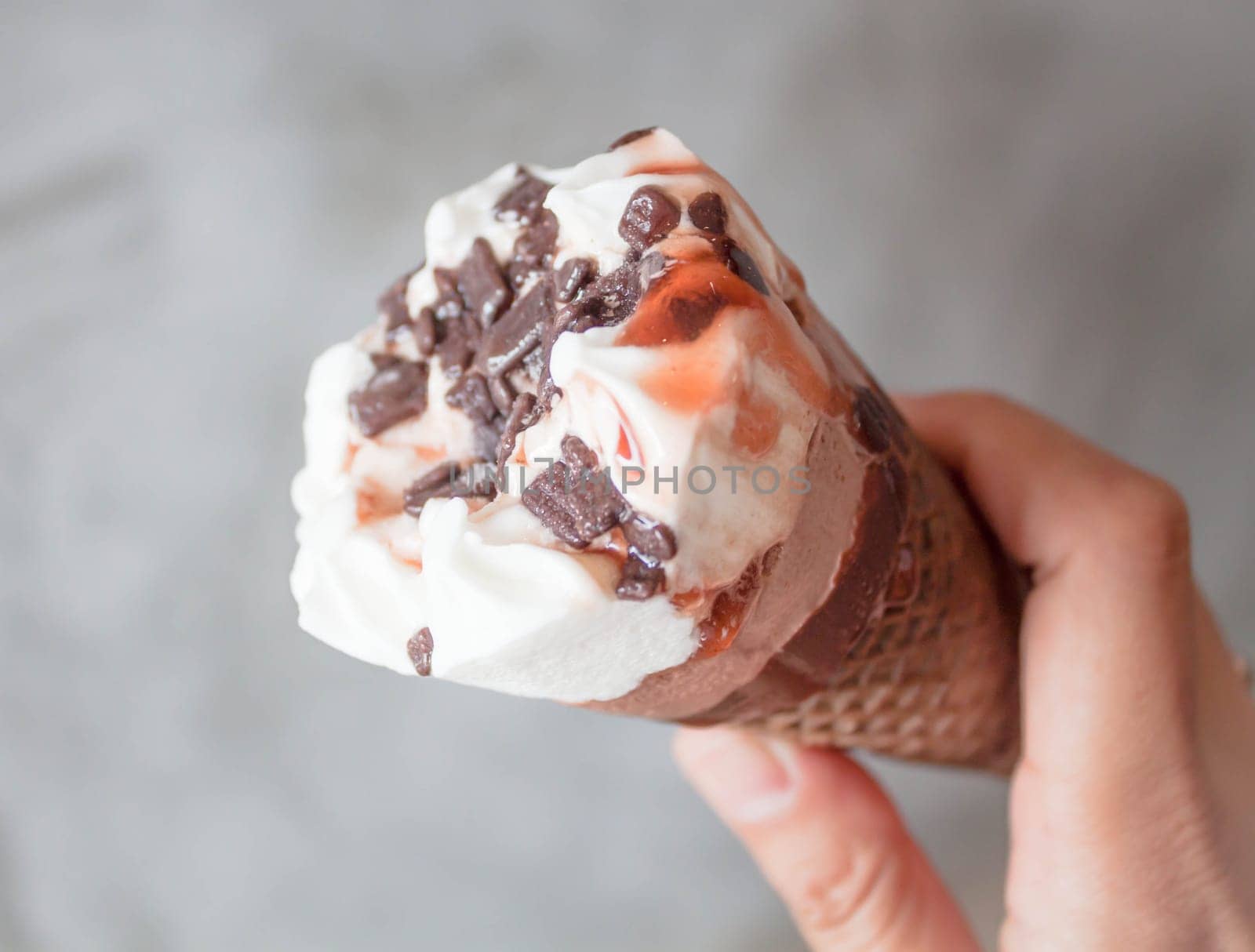 Melted ice cream in waffle cone in hand