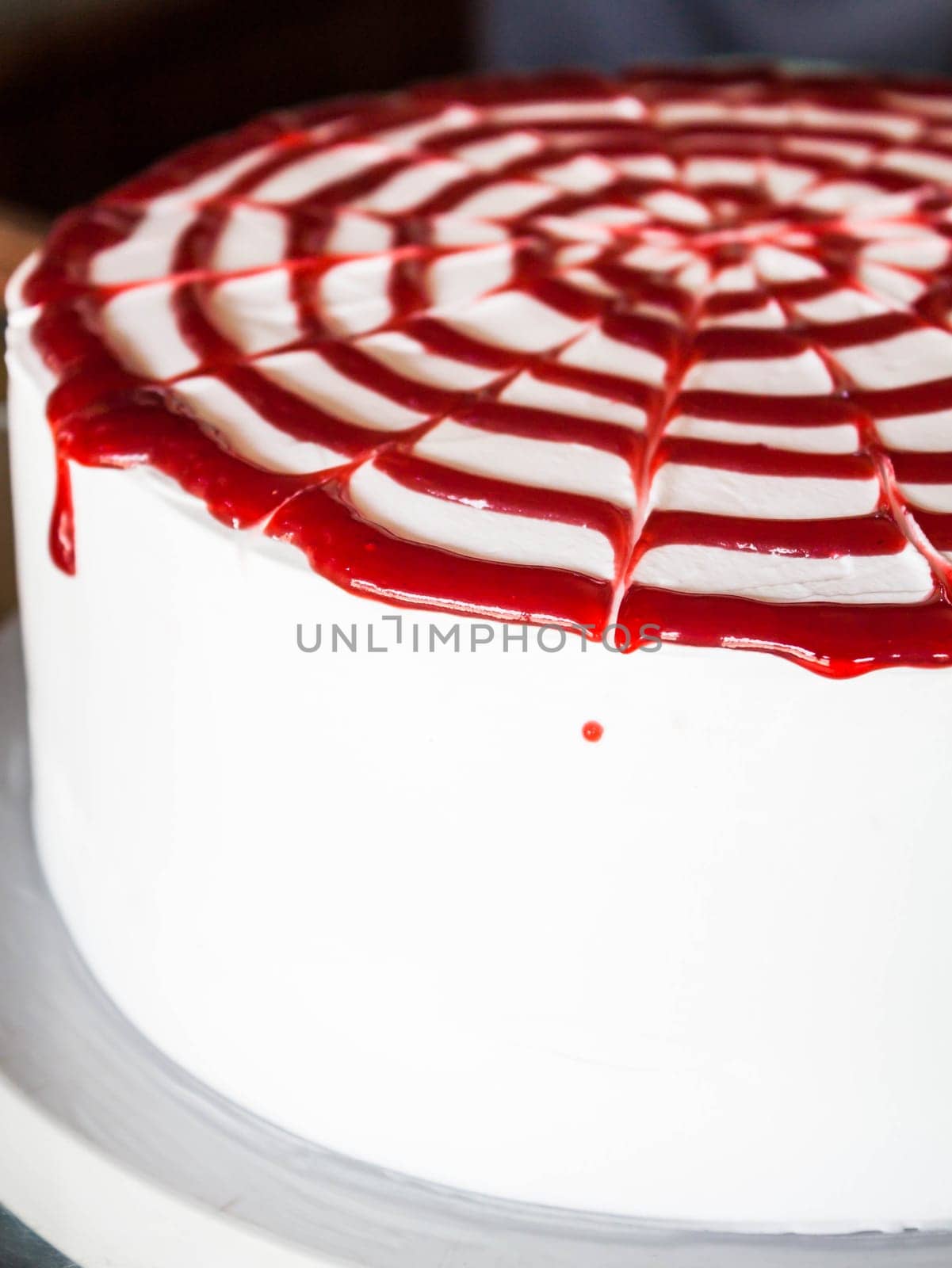 Raspberry sauce topped white whipped cream cake