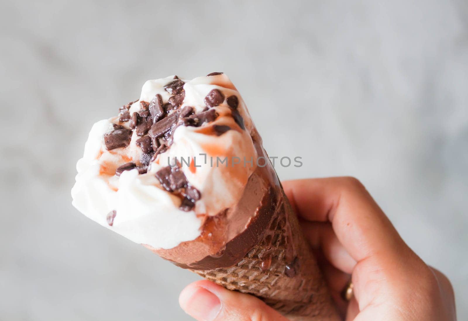 Melted ice cream in waffle cone in hand