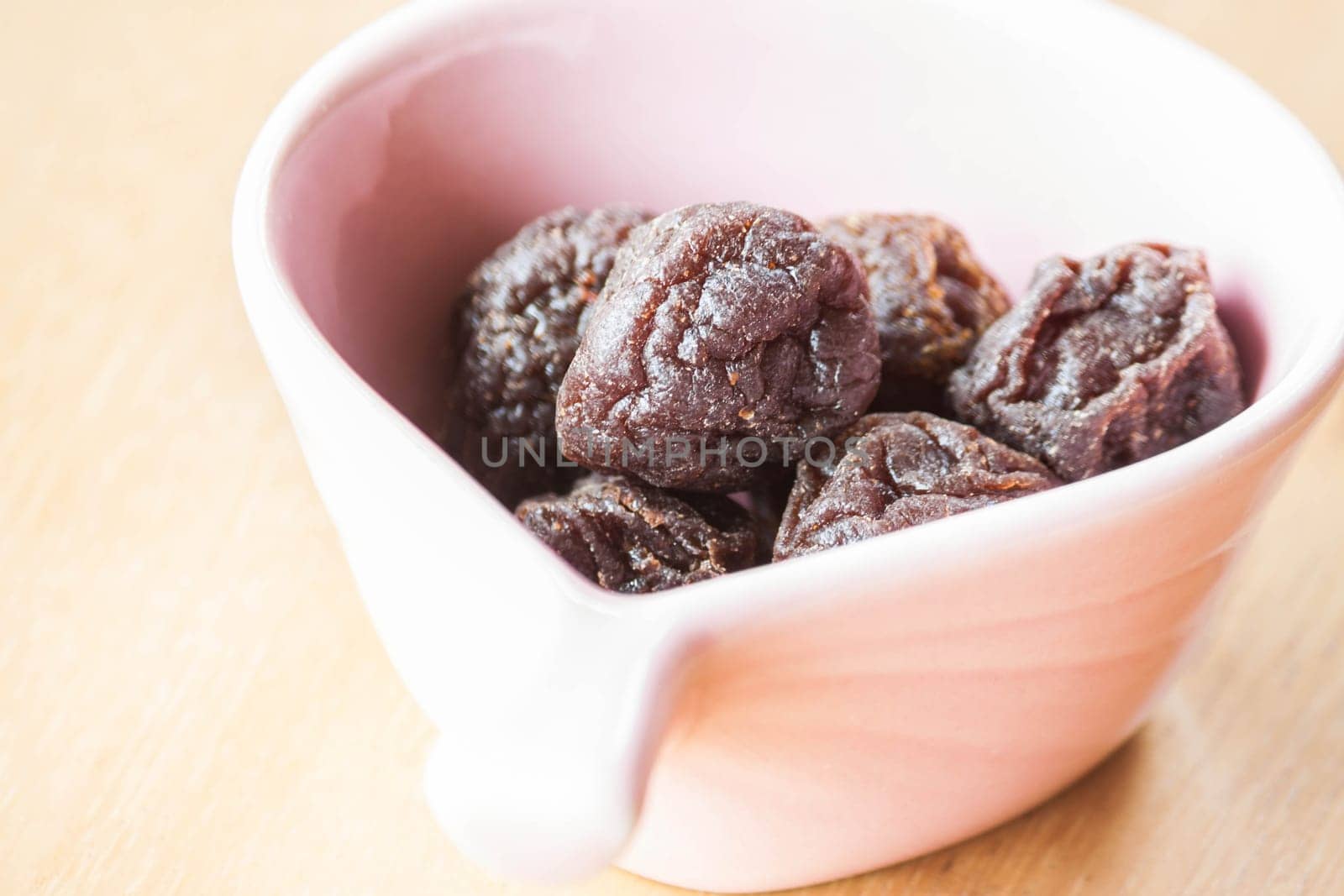 Close up delicious dried pink plum in cup