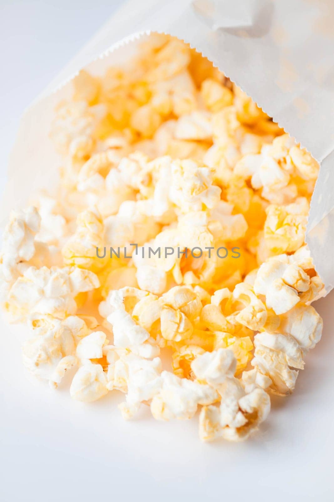 Fresh butter popcorn falling out of paper packet