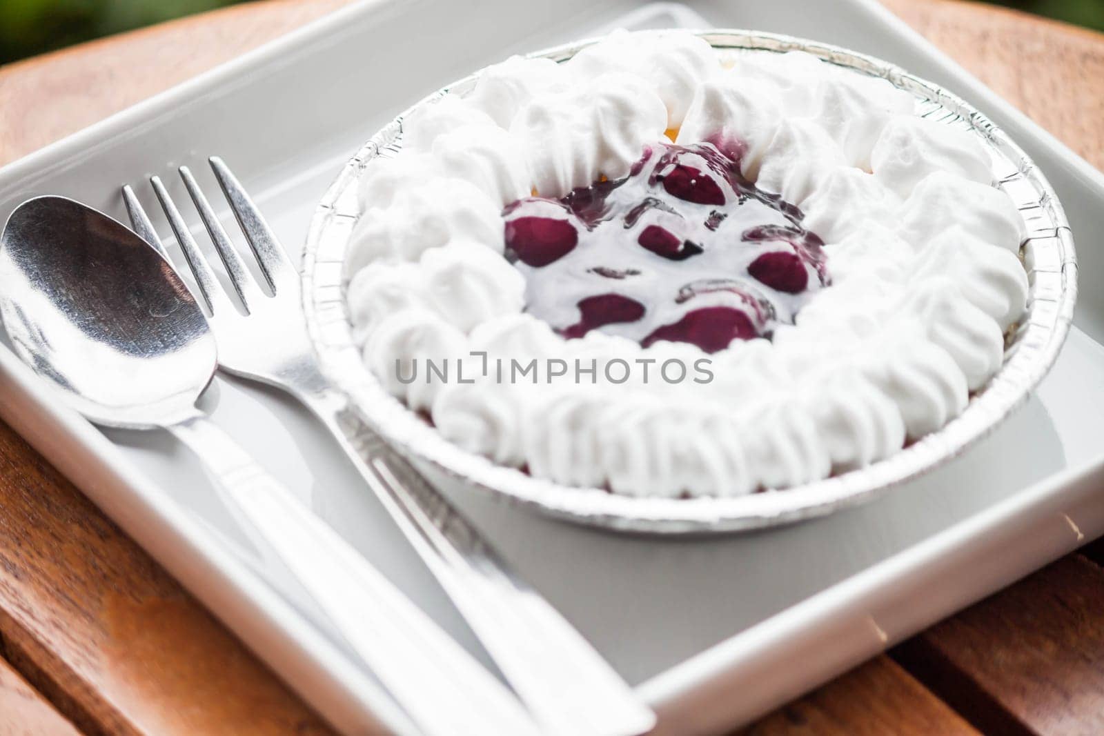 Blueberries sauce cheesecake serving on white plate