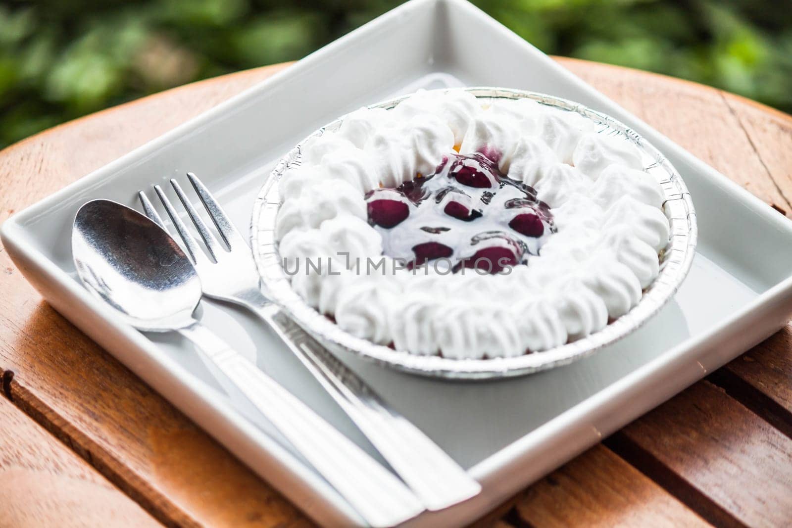 Cheesecake with blueberries sauce serving on white plate