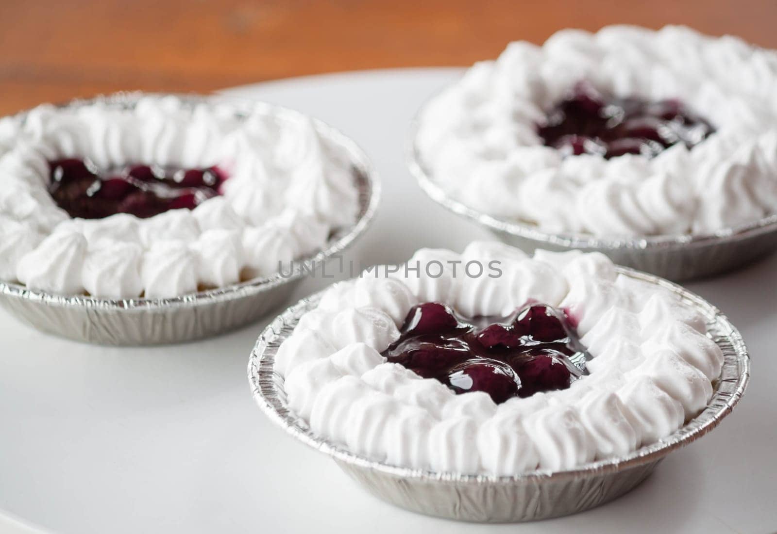 Dessert of blueberries cheese cupcake  topped with whipped cream