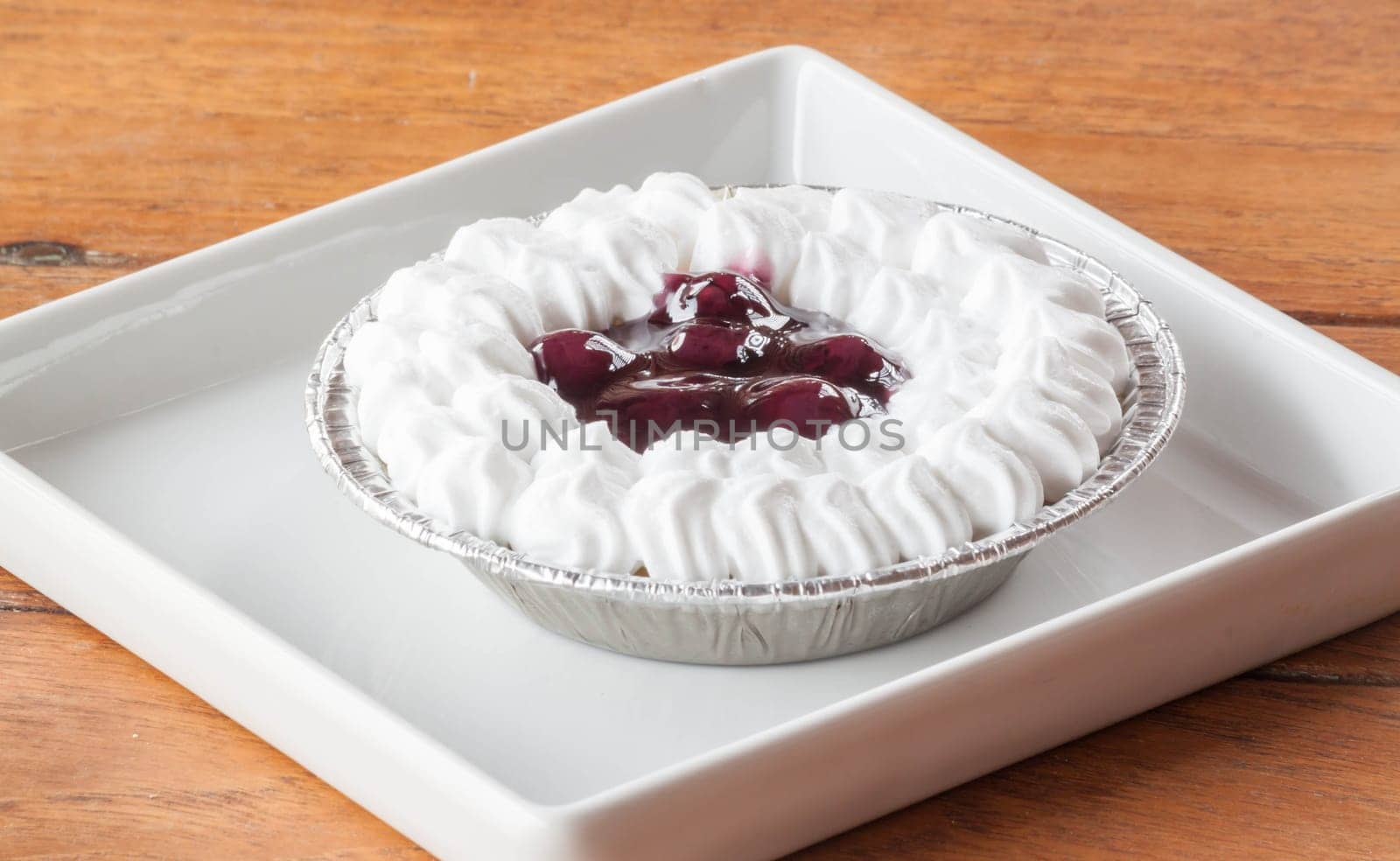 Blueberries cheesecake with whipped cream on a plate