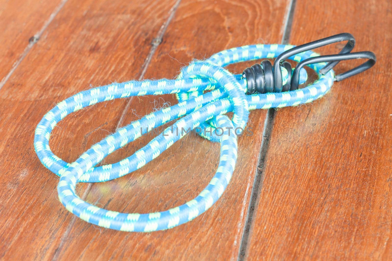 Light blue elastic rope on wood background